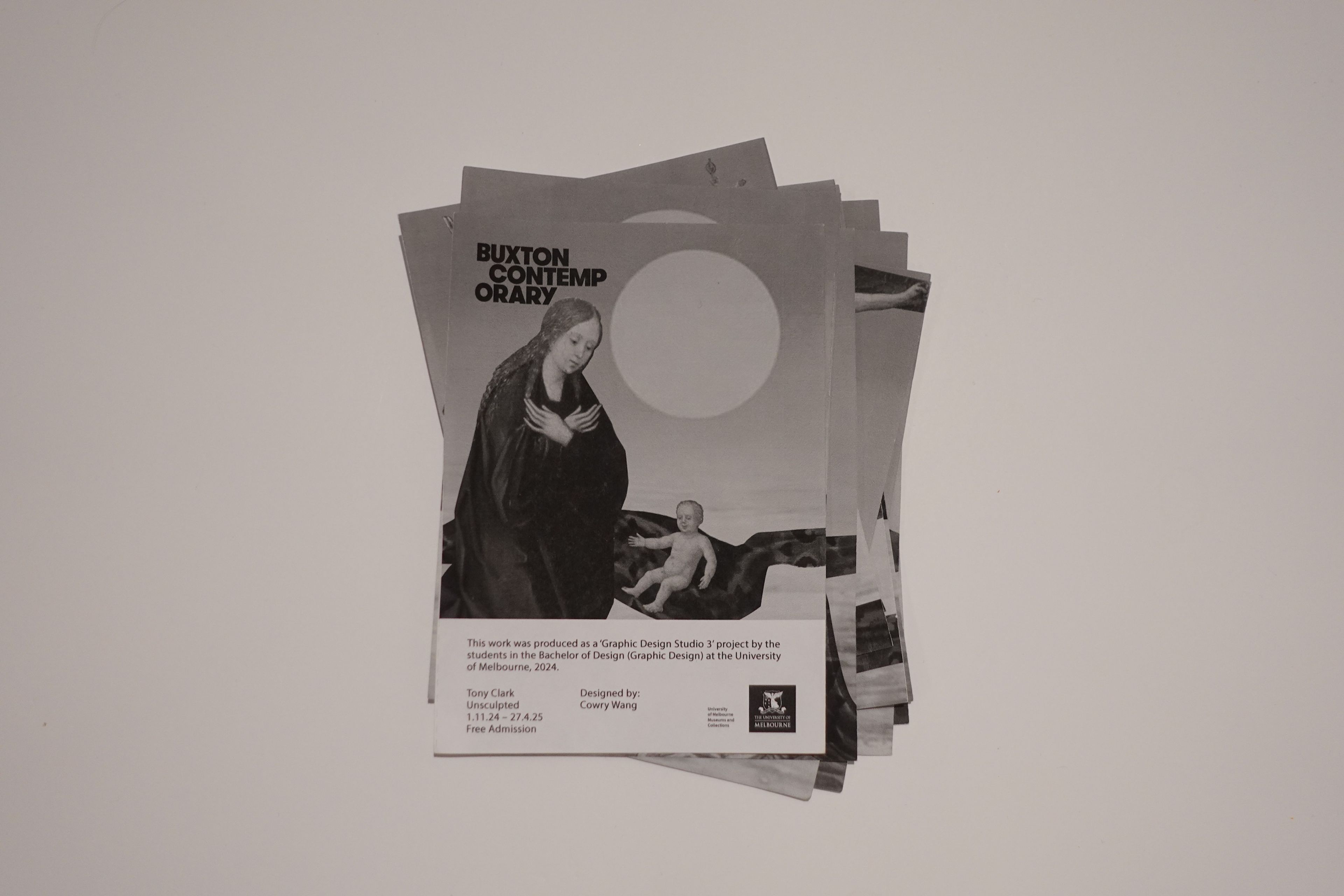 Stack of black and white flyers for Buxton Contemporary, featuring a classical painting of a woman in dark clothing and a child set against a blank, modern background with a large white circle. The flyer text notes this as a university graphic design project.