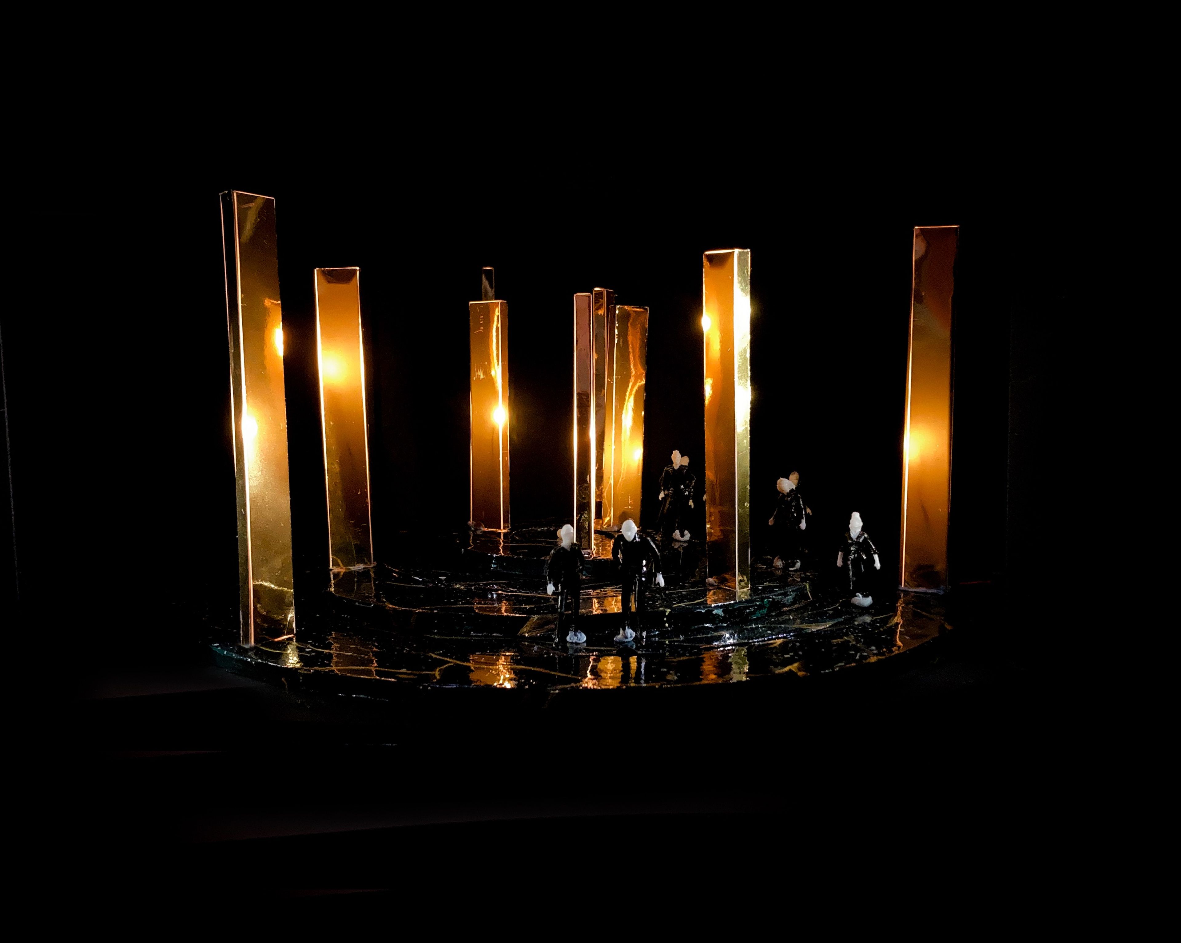 Set model for Act 5, Scene 8, with golden columns and several figures scattered on a dark stage.