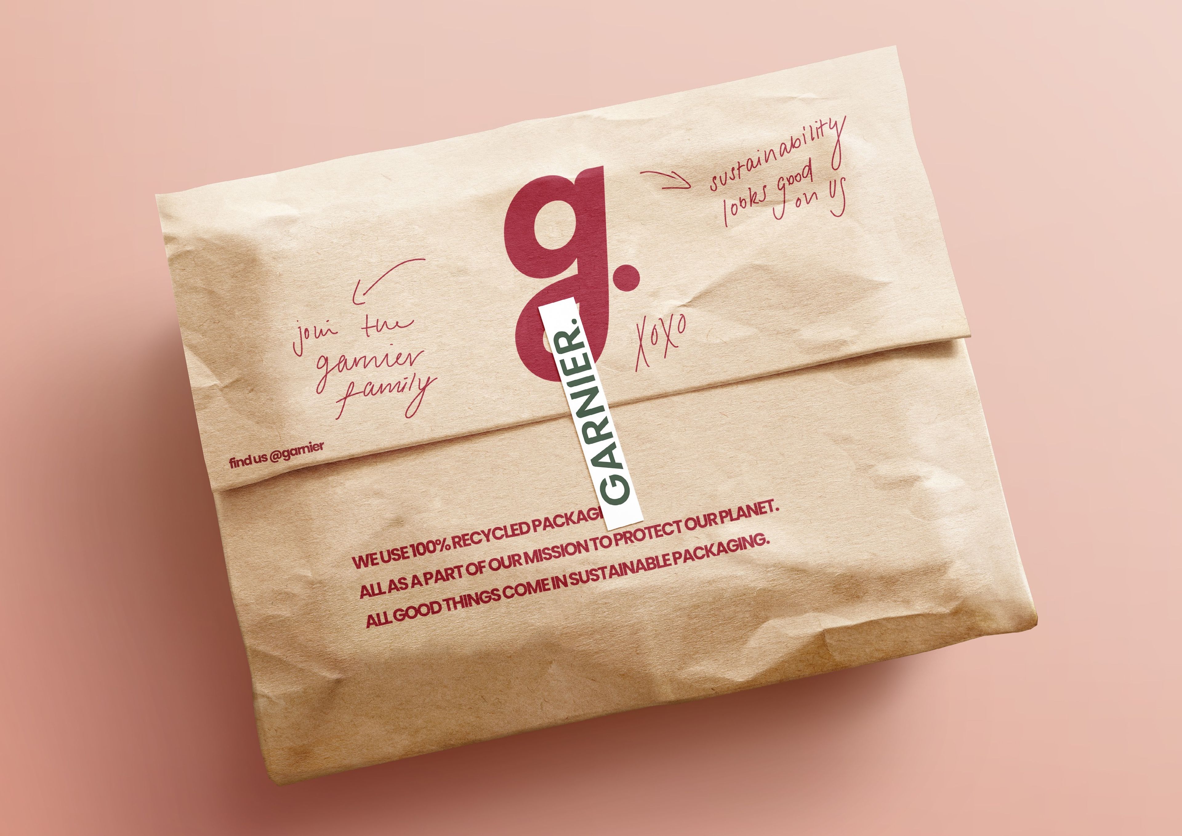 Brown paper packaging branded with Garnier's logo and sustainability messaging. Handwritten annotations in red read, "Join the Garnier family" and "Sustainability looks good on us." A tagline at the bottom highlights the use of "100% recycled packaging".