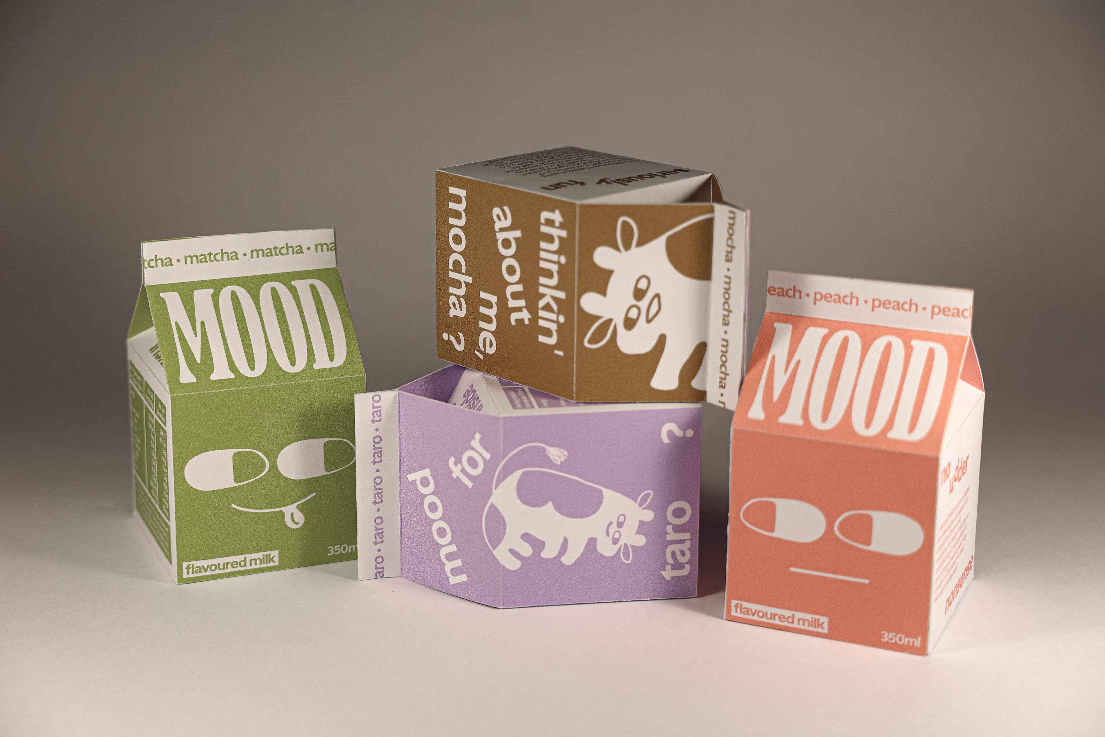 Product packaging design for 'MOOD' flavoured milk in various colours: matcha green, peach orange, taro purple, and mocha brown. Each carton features minimalist, playful illustrated faces.