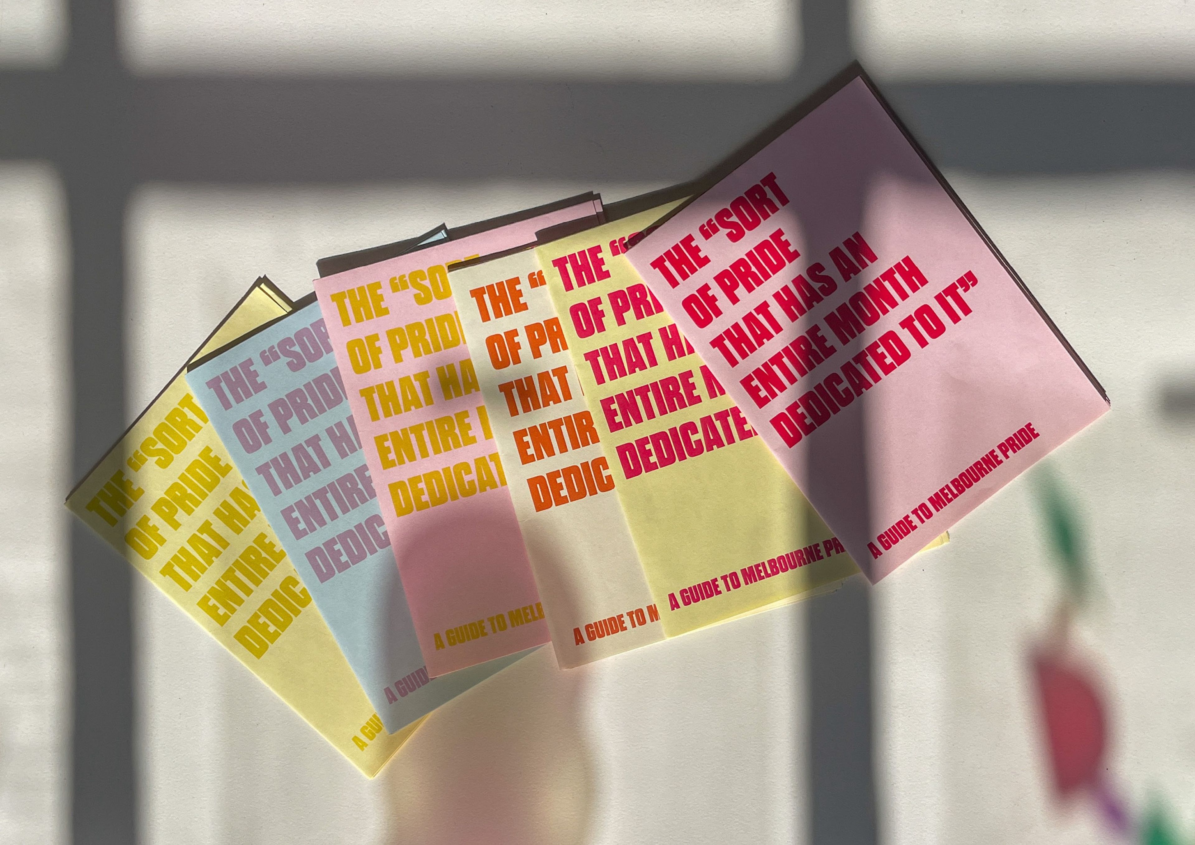 Five pastel-coloured publication covers arranged in fan layout, featuring repeated text 'THE "SORT OF PRIDE" THAT HAS AN ENTIRE MONTH DEDICATED TO IT'. Subtitled 'A GUIDE TO MELBOURNE PRIDE' with text appearing in gradient colours from yellow to pink.