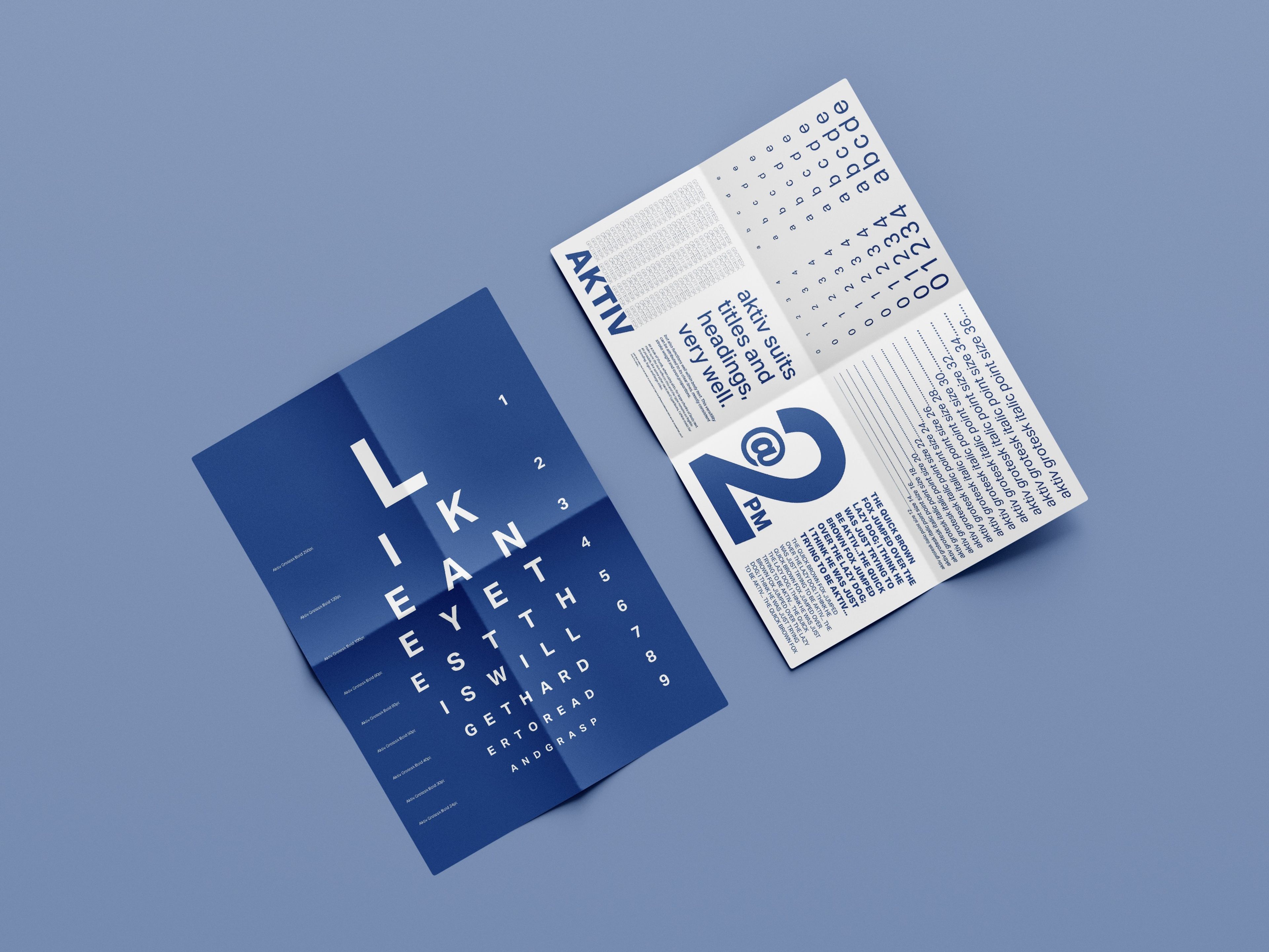 A folded typographic brochure with bold blue and white designs, resembling an eye chart on one side with large letters and a crossword-style layout on the other side. The typography is clean and modern, utilising hierarchy to highlight specific headings and details about the font.