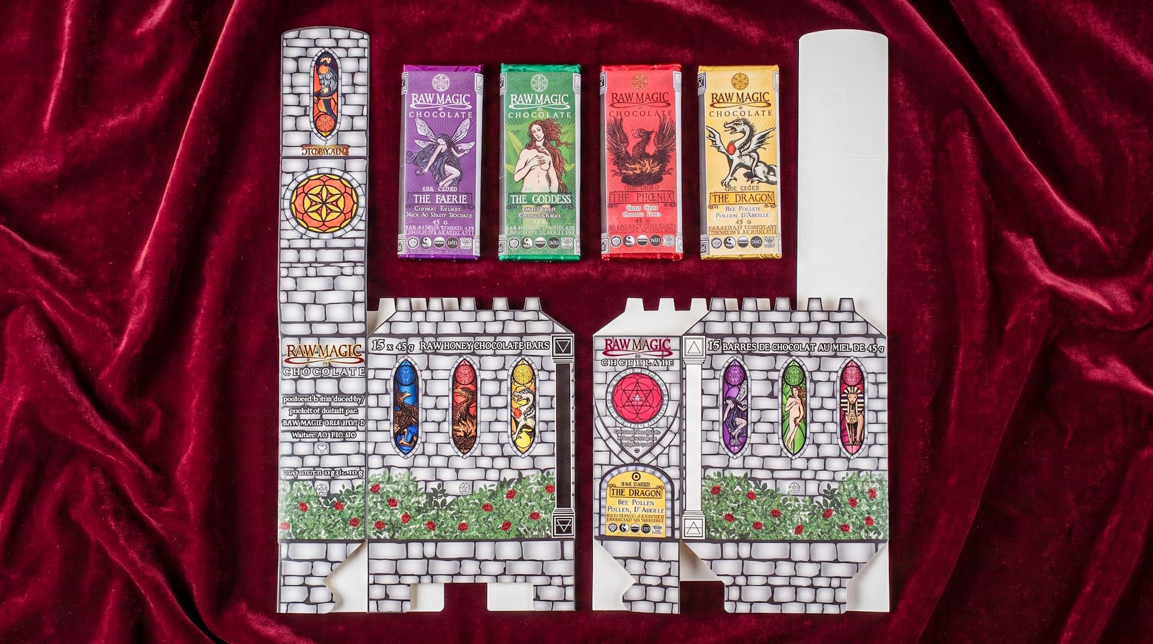 Flat, unfolded castle packaging next to four colorful Raw Magic Chocolate bars on a red velvet backdrop.