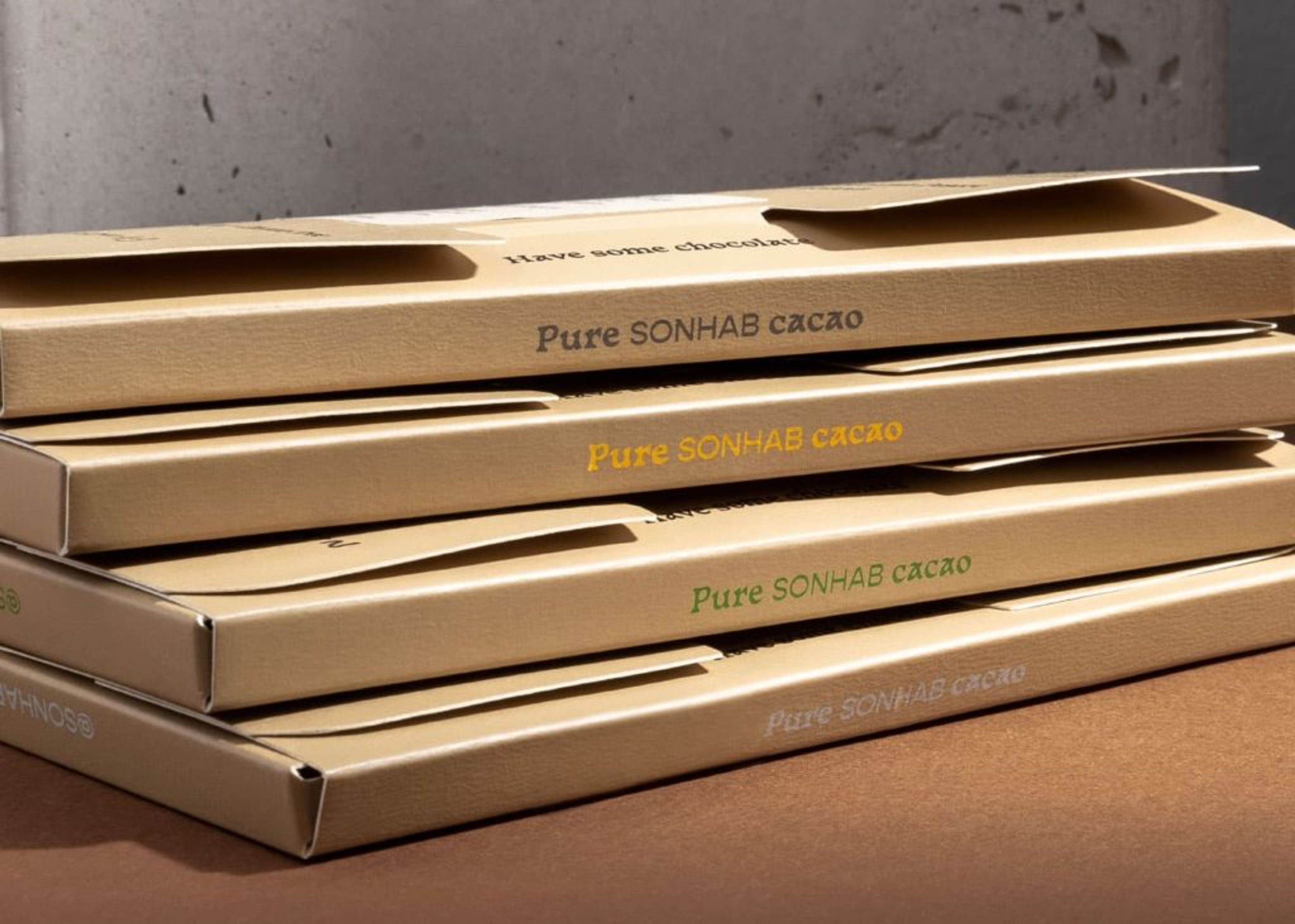 A stack of four Sonhab chocolate boxes showing the side panels with "Pure SONHAB cacao" printed in different colors.