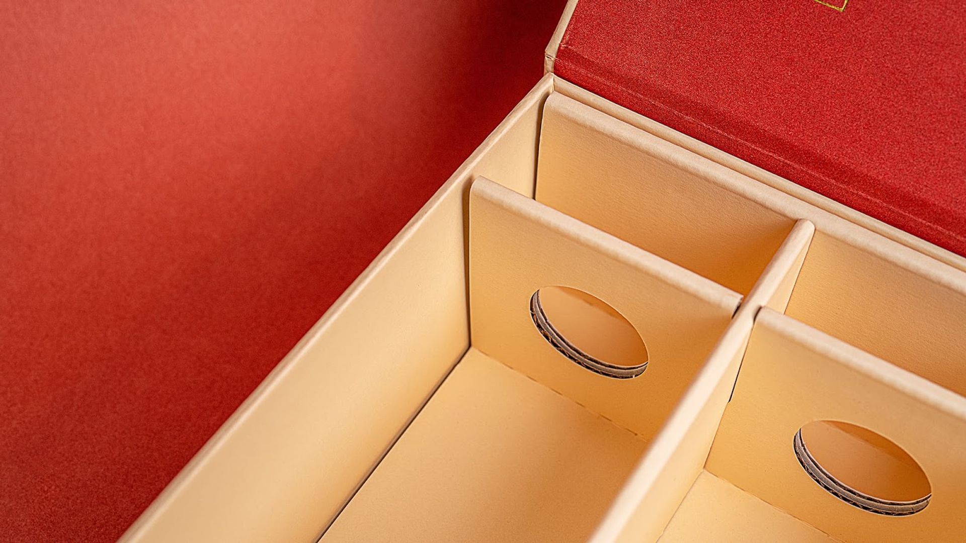 Close-up of the custom cream corrugated packaging insert with circular cutouts for cocktail bottles.