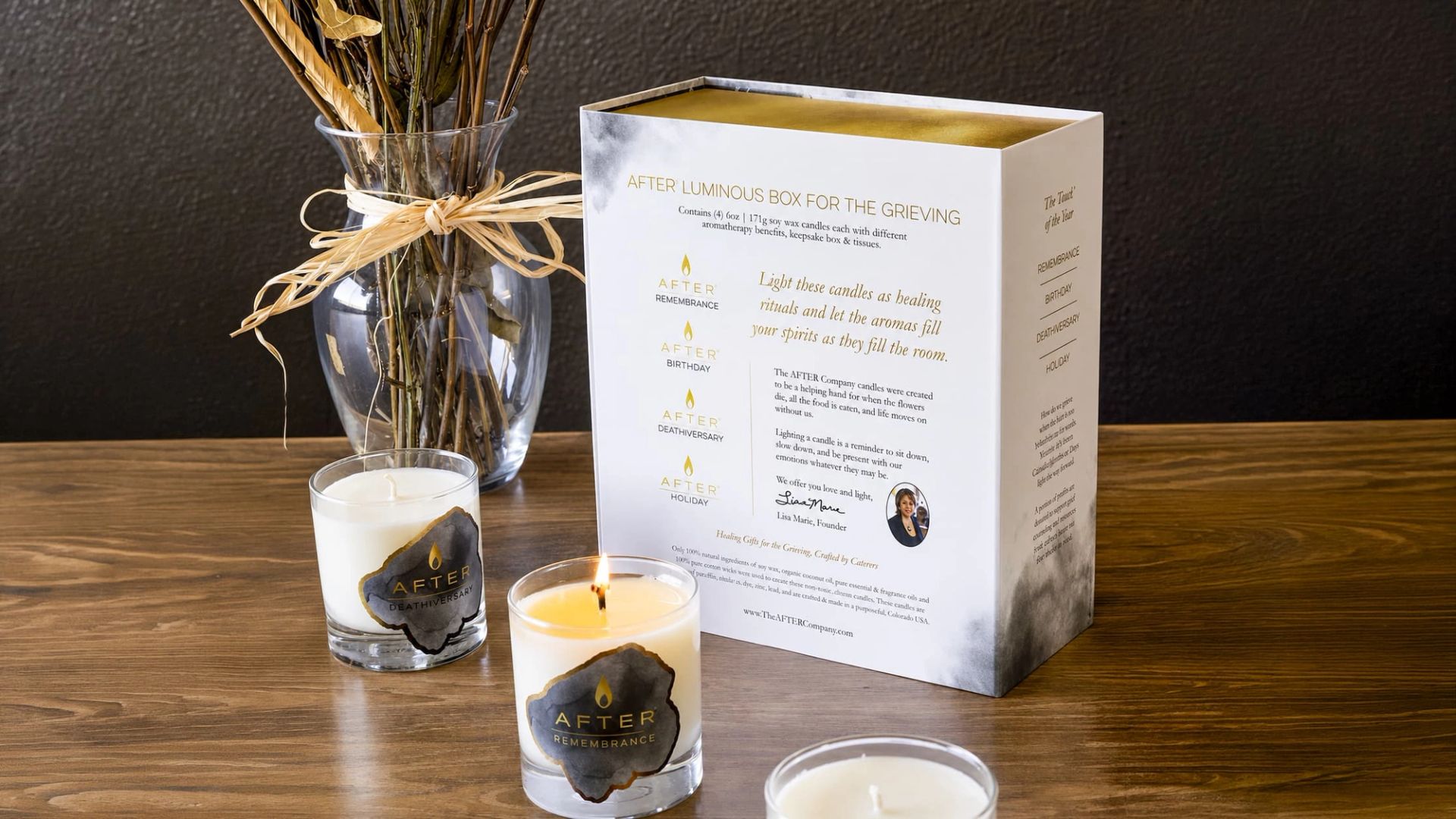 Back of AFTER Luminous Box for the Grieving next to lit and unlit glass candles and a vase of dried flowers.