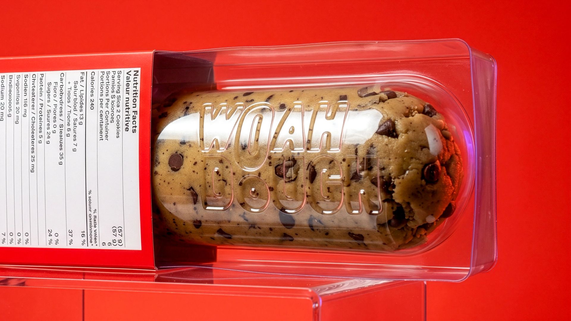 Chocolate chip cookie dough log in a clear blister pack embossed with "WOAH DOUGH", partially pulled from a red carton.