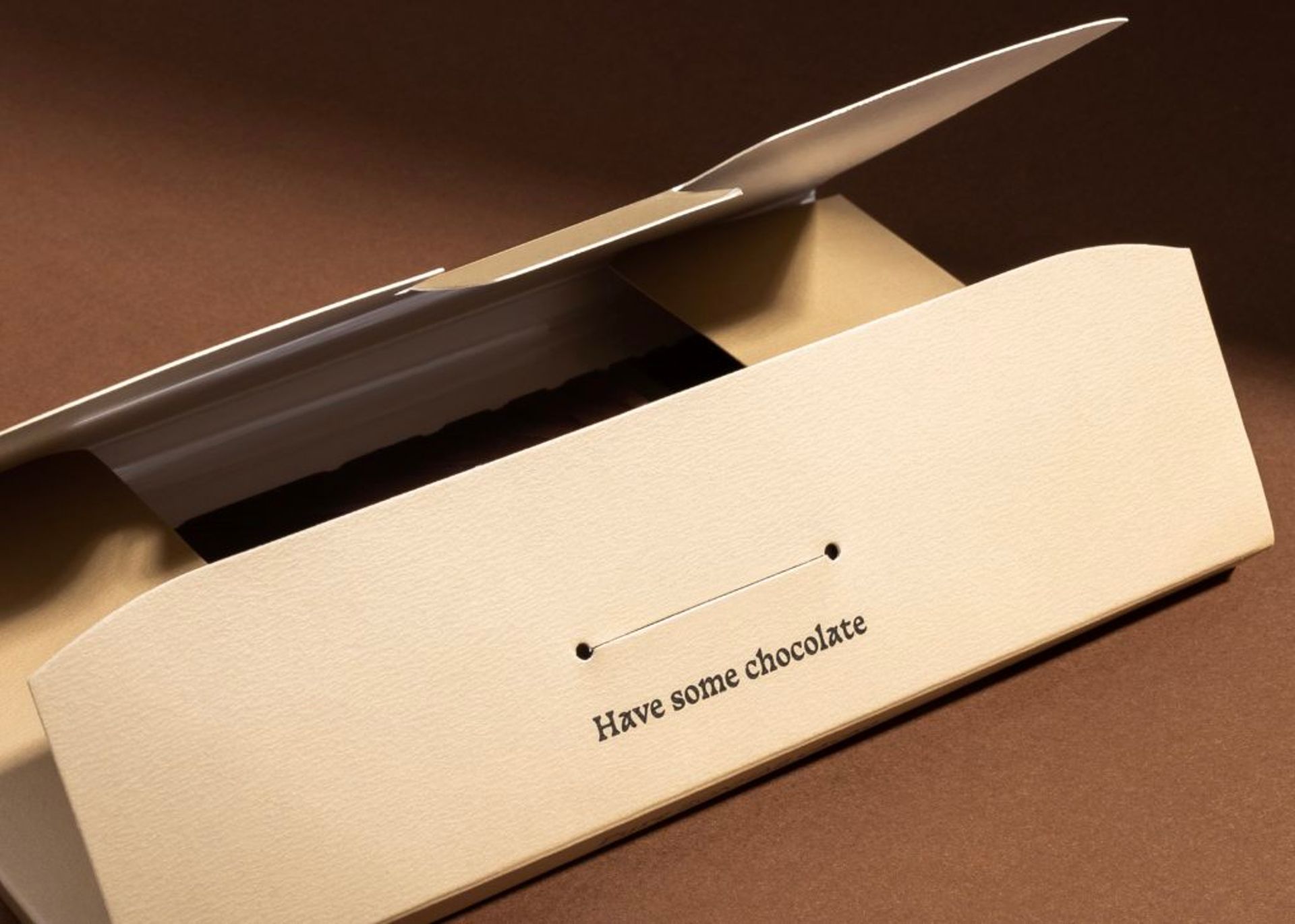 Close-up of a partially open Sonhab chocolate box demonstrating its custom envelope-style folding closure mechanism.