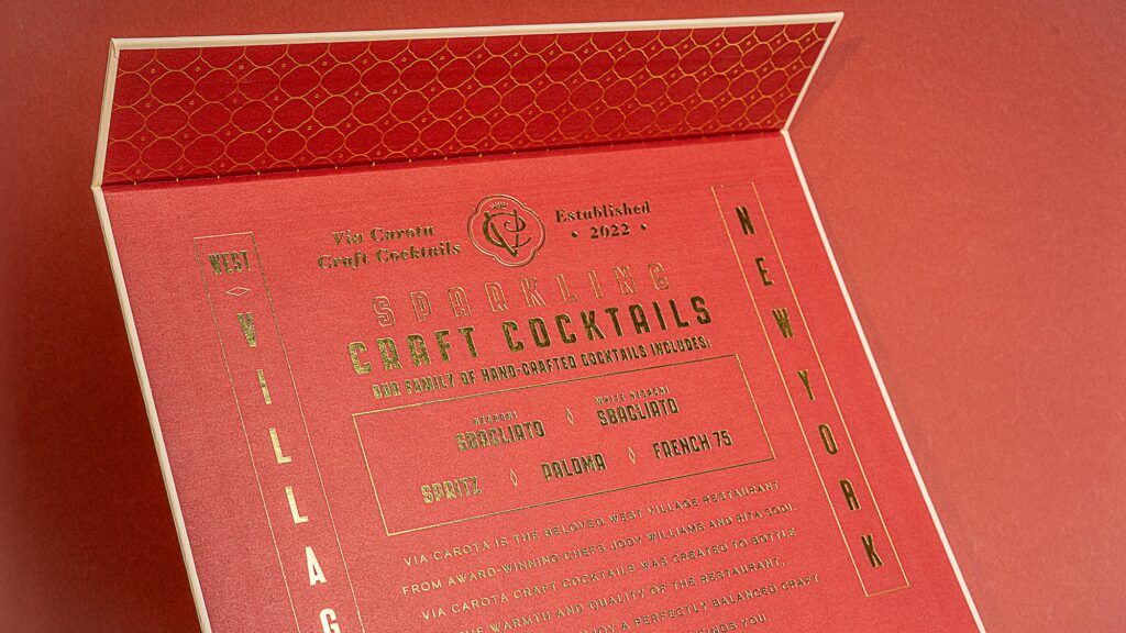 Detailed view of the red interior box lid featuring elegant gold foil typography and branding text.