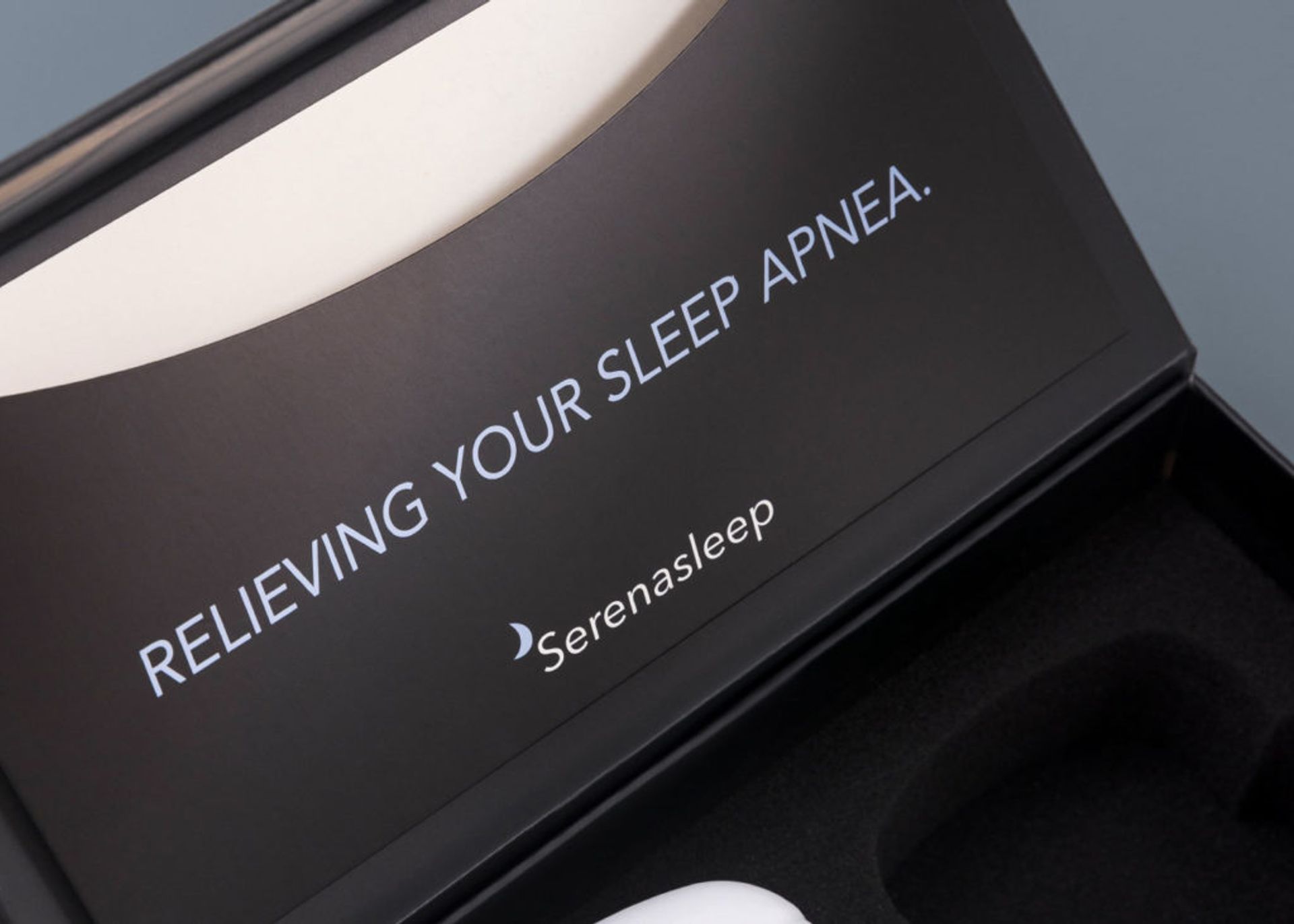 Close-up of a matte black lid with white text reading 'RELIEVING YOUR SLEEP APNEA.' above the Serena Sleep logo.