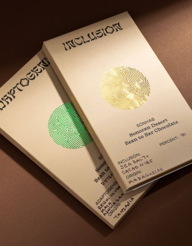 Close-up of Sonhab Adaptogenic and Inclusion chocolate boxes showing premium textured paper and detailed foil stamping.
