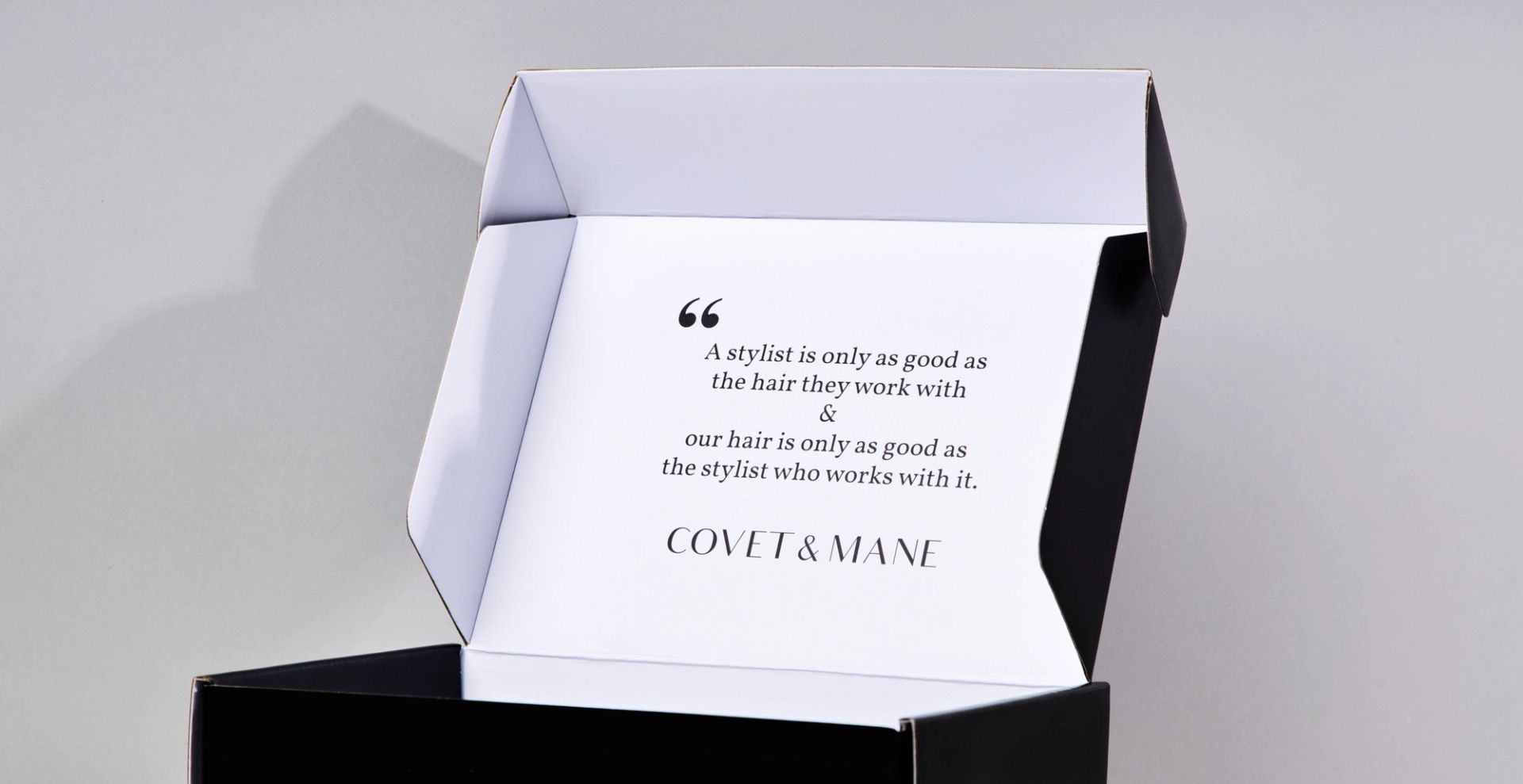 Close-up of an open Covet & Mane mailer box highlighting the quote printed on the white interior flap.