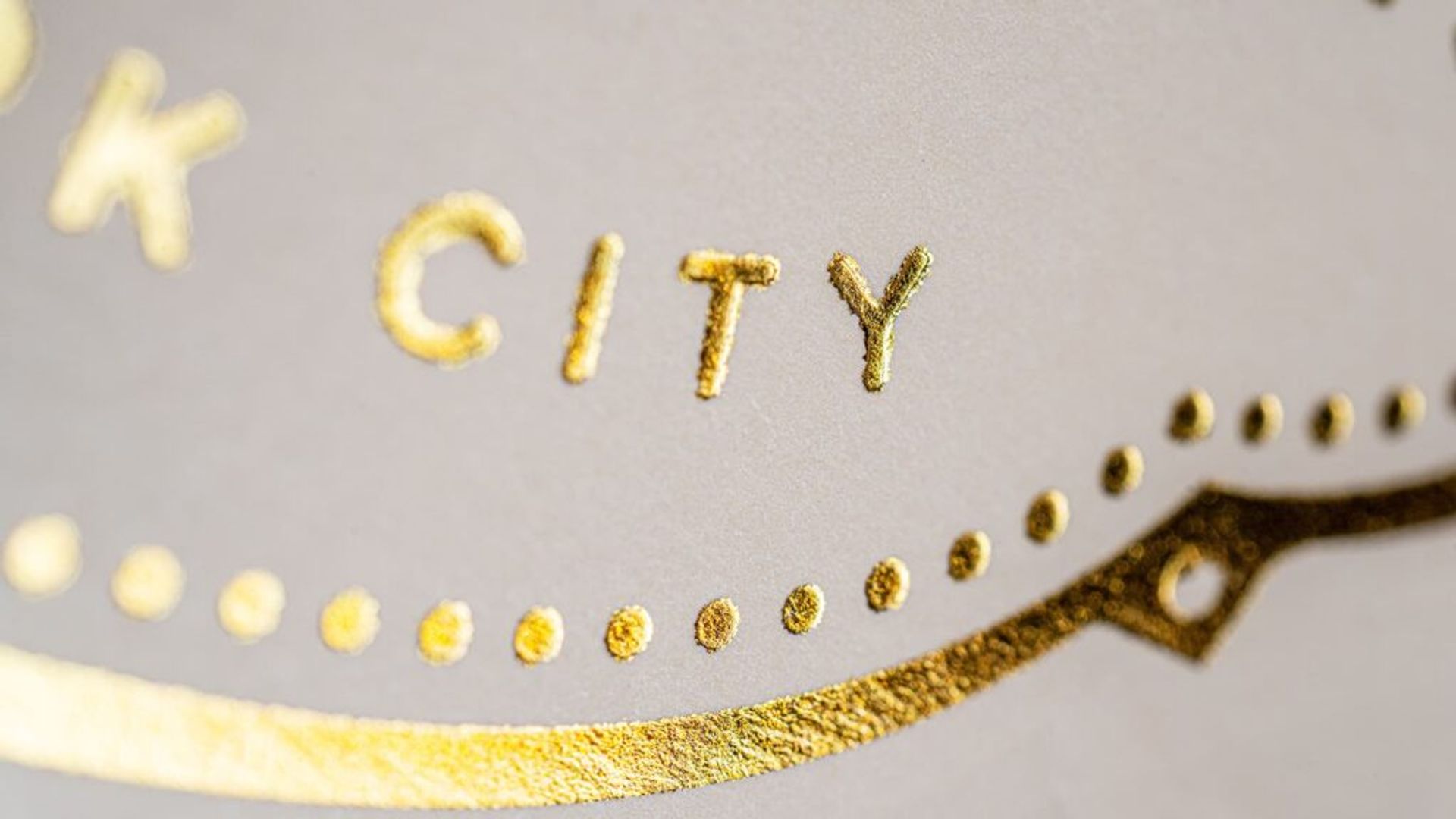 Macro view of the metallic gold foil embossed lettering on the custom cocktail gift packaging.