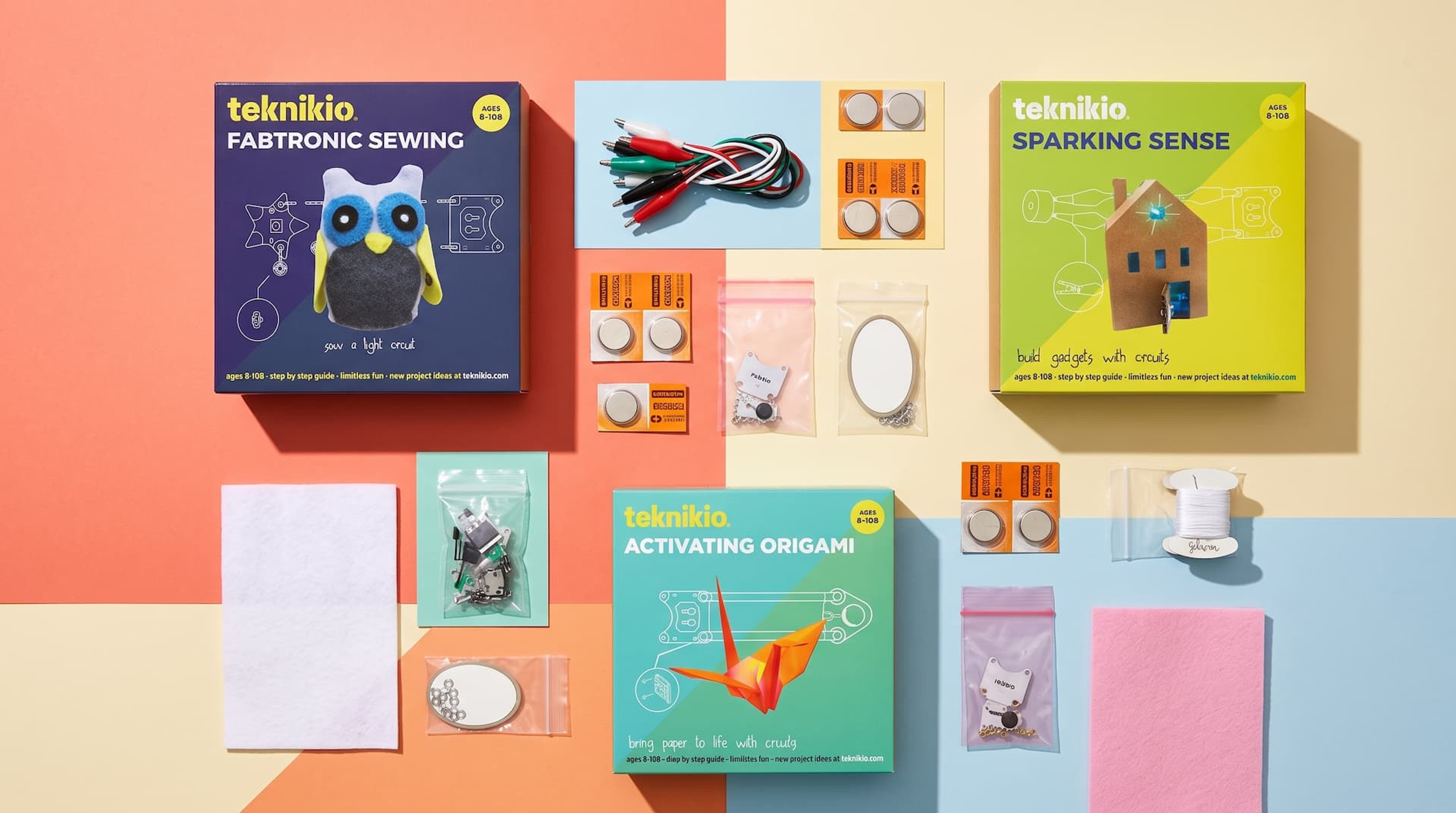 Flat lay of three Teknikio kit boxes arranged alongside their respective electronic components on a colorful background.