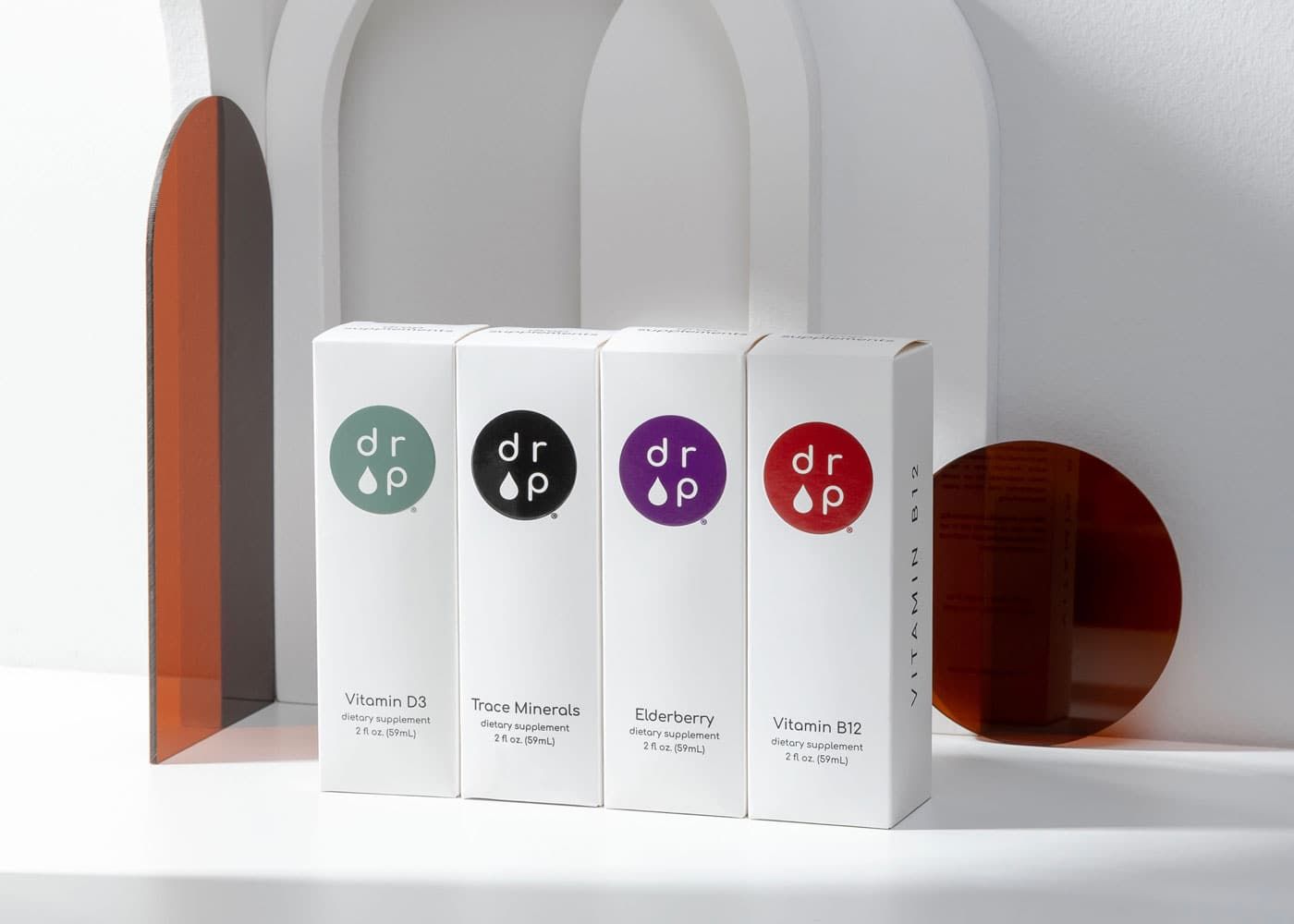 Four white Drop Supplement boxes lined up neatly, displaying green, black, purple, and red circle logos.