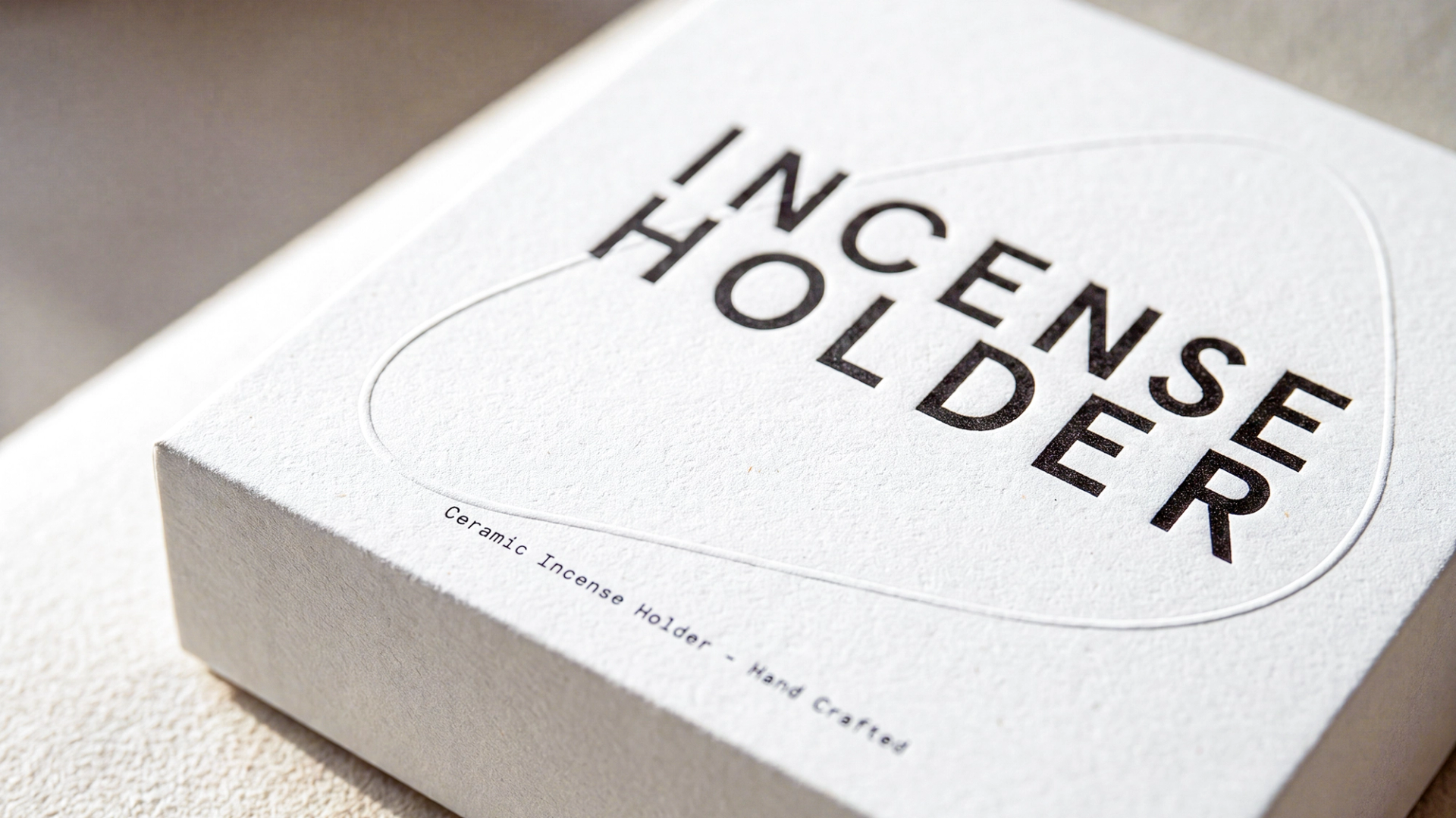 A close-up of a textured white box with "INCENSE HOLDER" printed in bold black letters.
