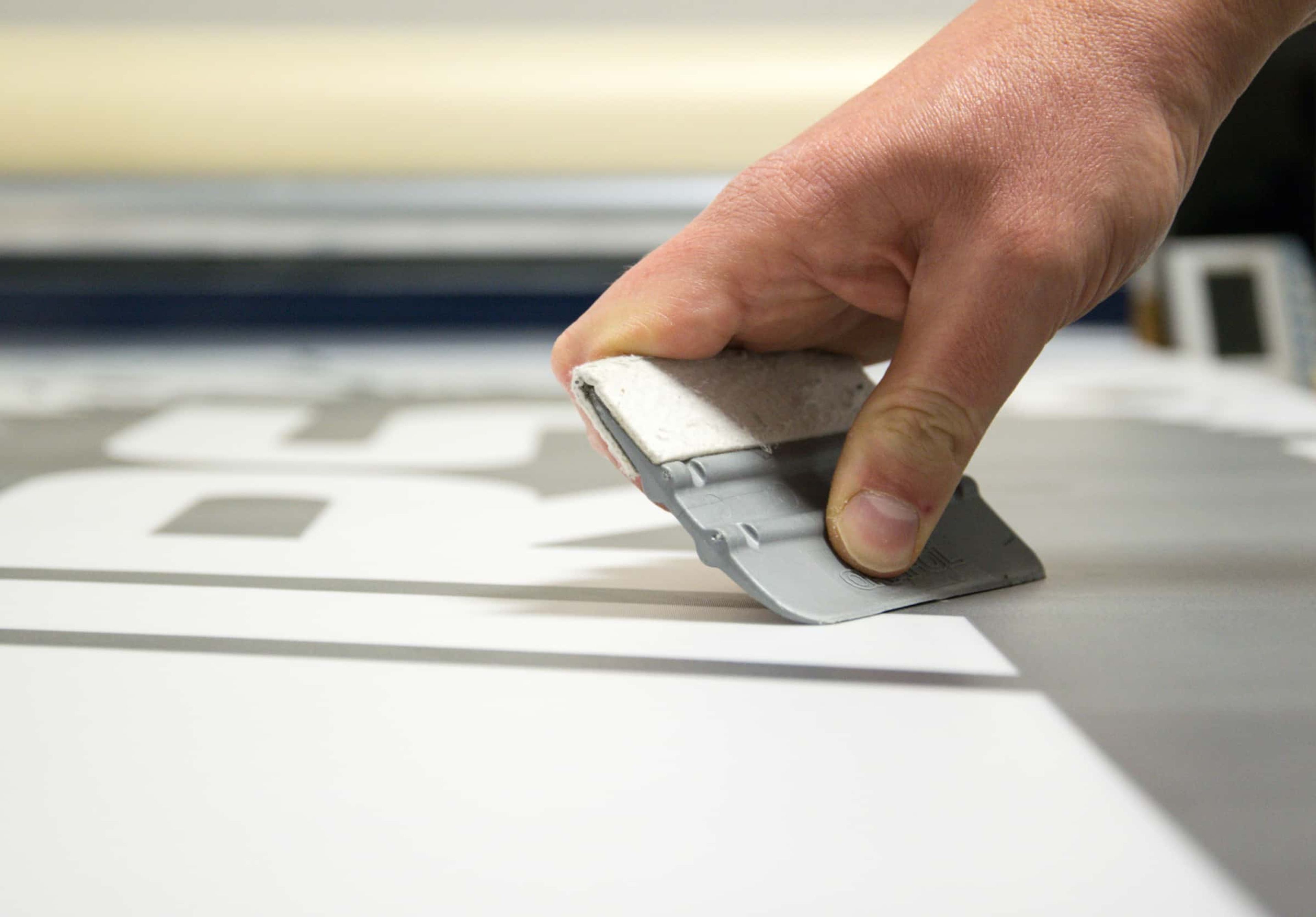 scrapping the air bubbles while applying decal on surface