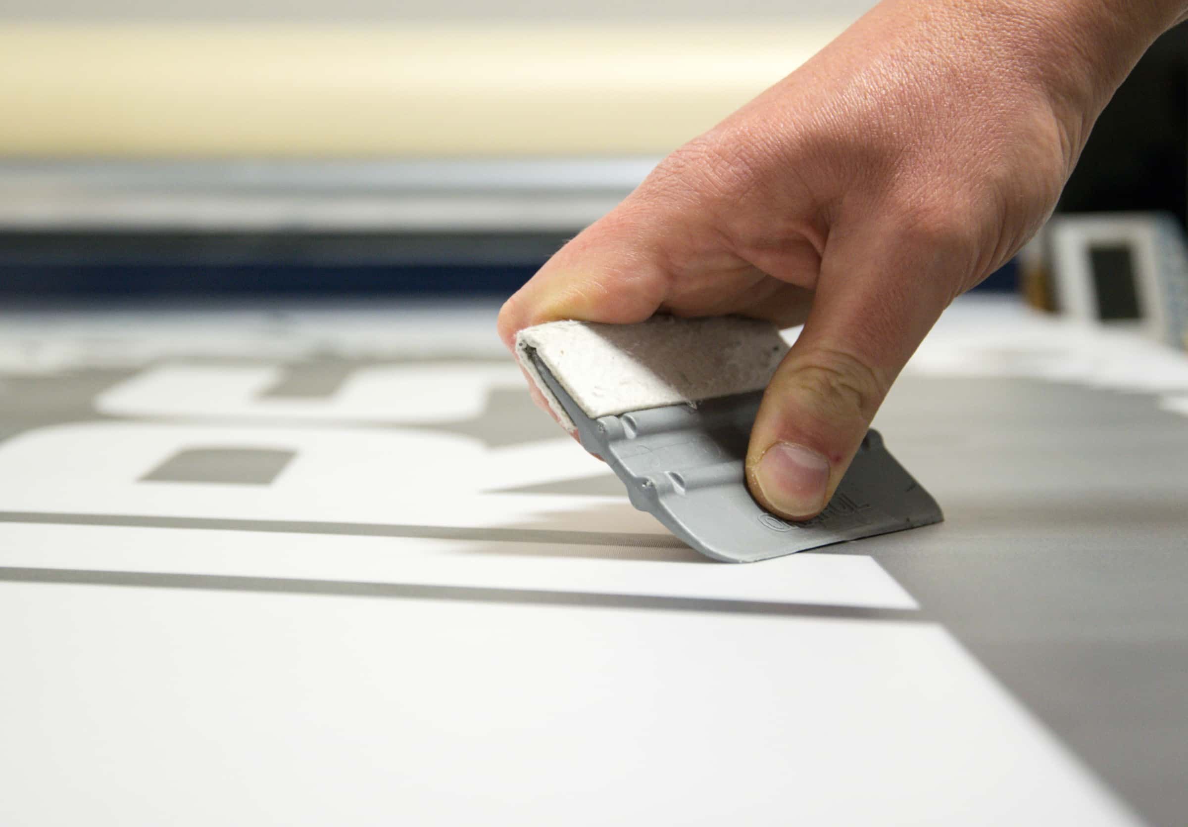 scrapping the air bubbles while applying decal on surface
