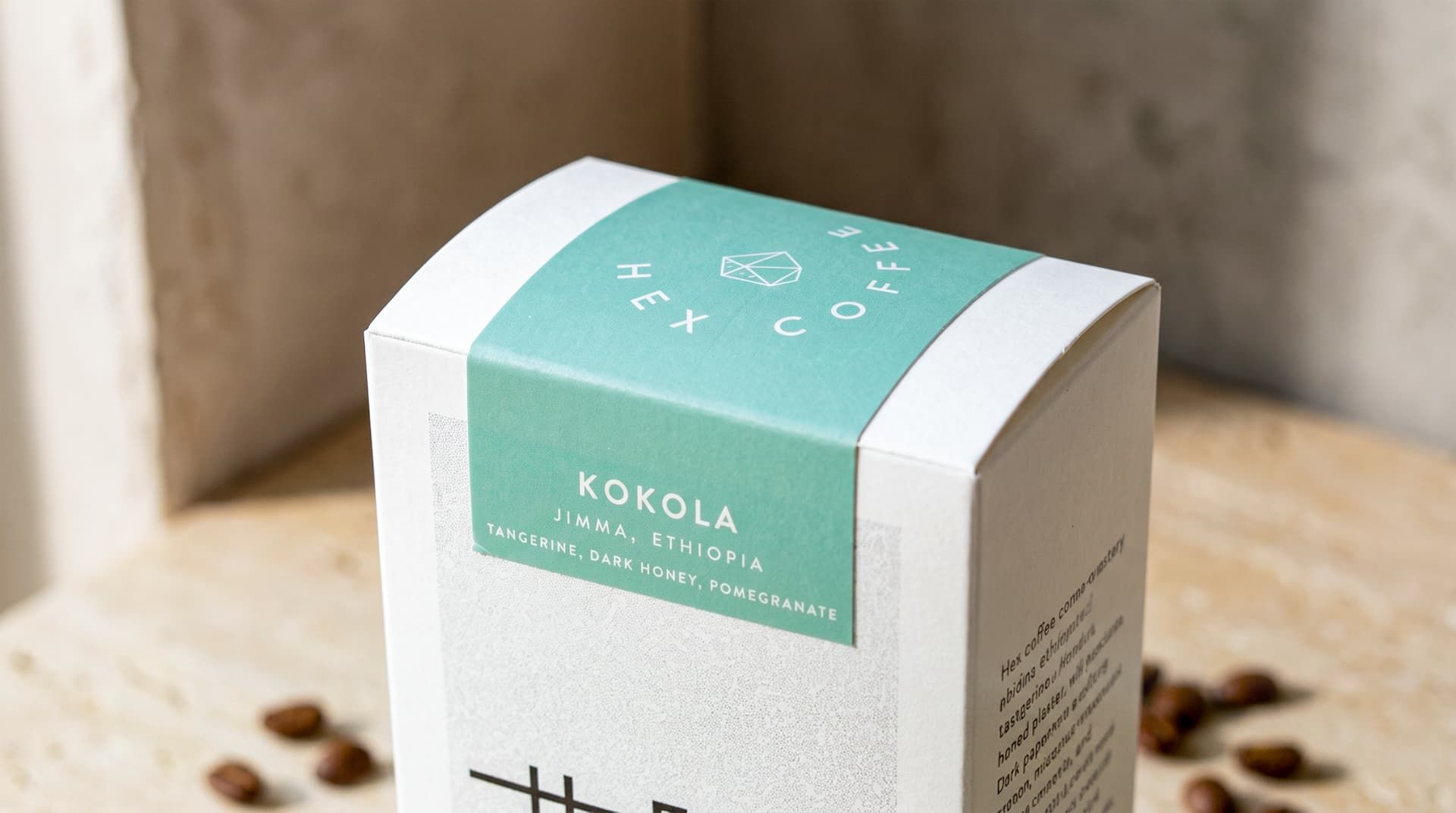 Close-up of a Hex Coffee box showing a mint green wrap-around label for Kokola, Ethiopia, secured over the top edge.