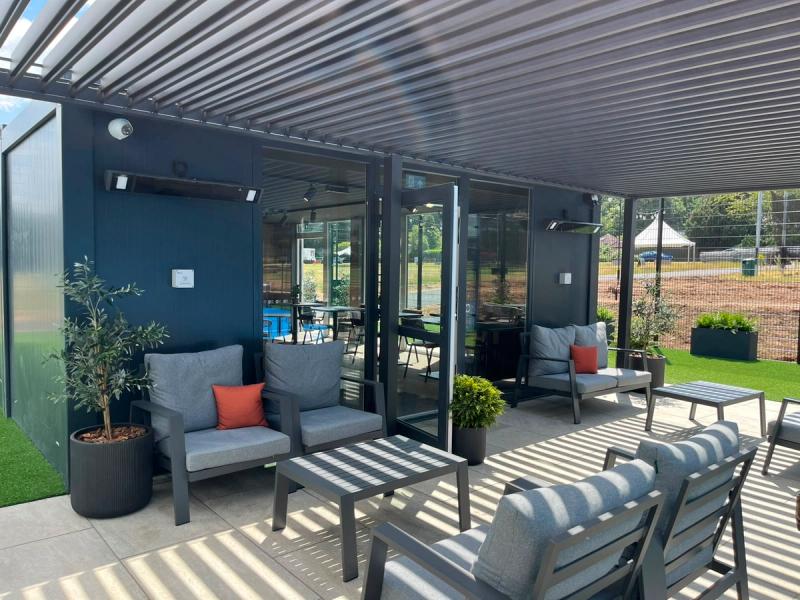 Pur Padel cafe showing exterior relaxation area with lighting, heaters and security