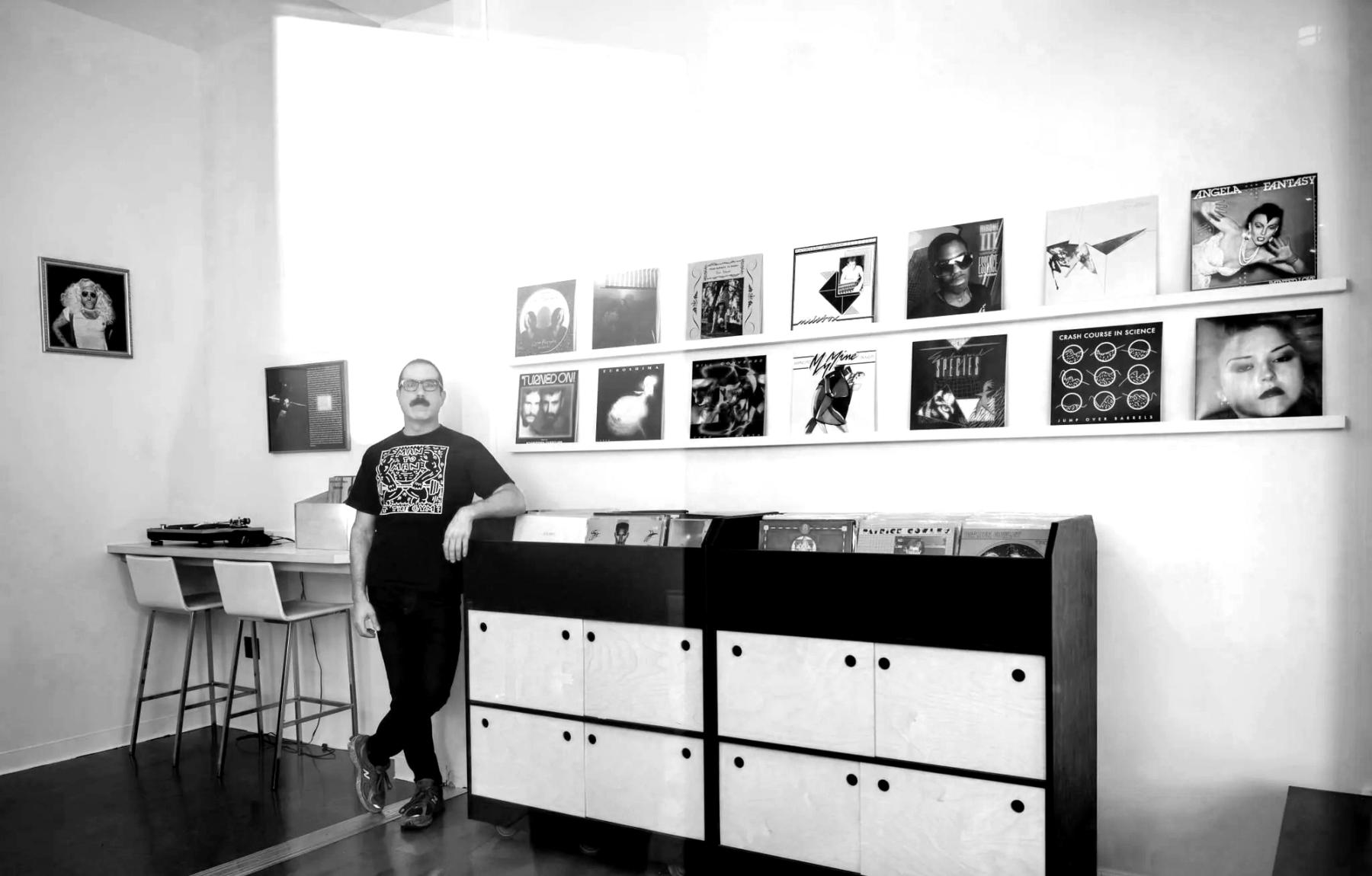 Interior of Dark Entries Records with proprietor and records on shelves and hung on the wall