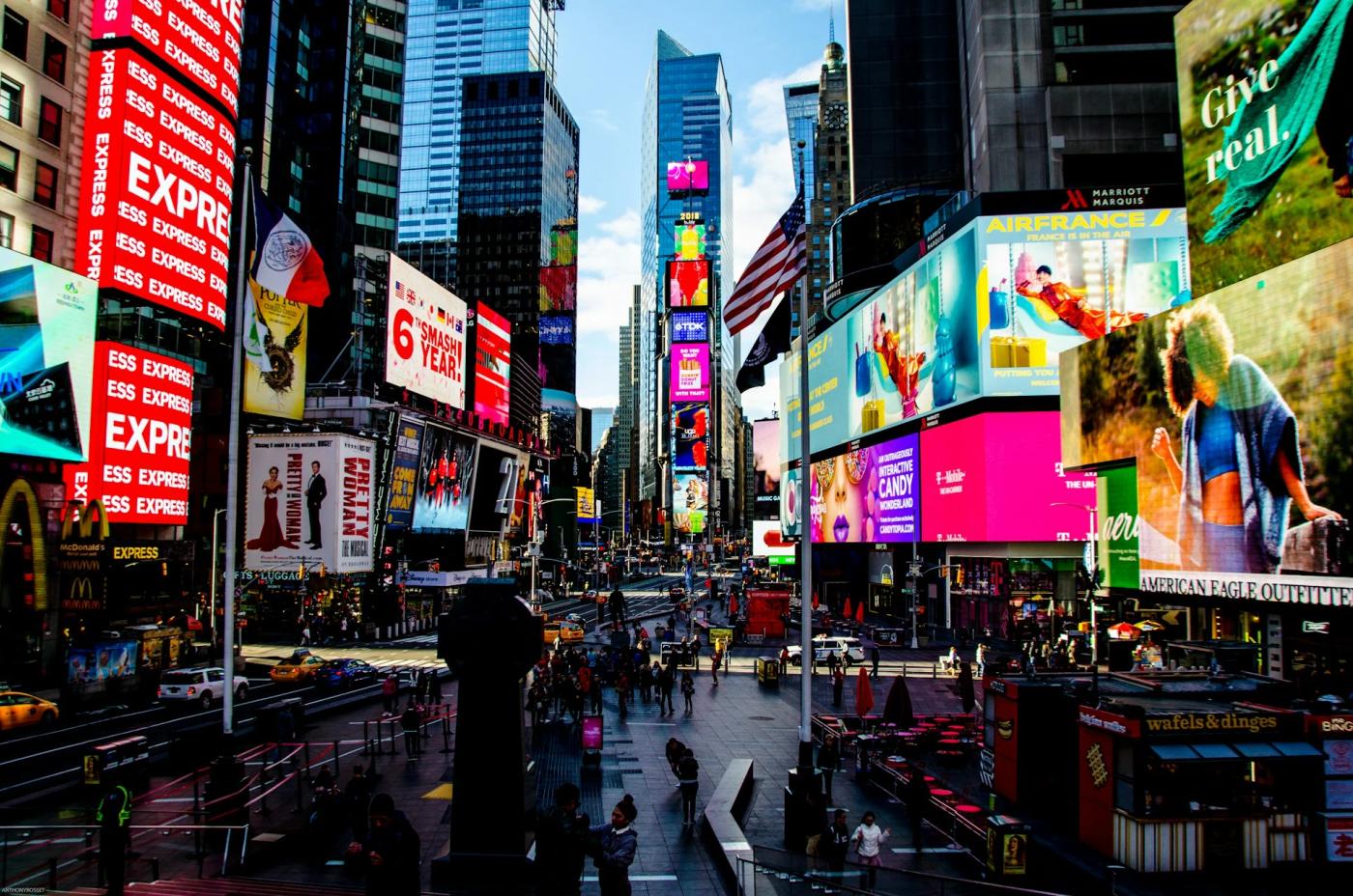 Times Square billboards and digital ads towering over pedestrians in New York