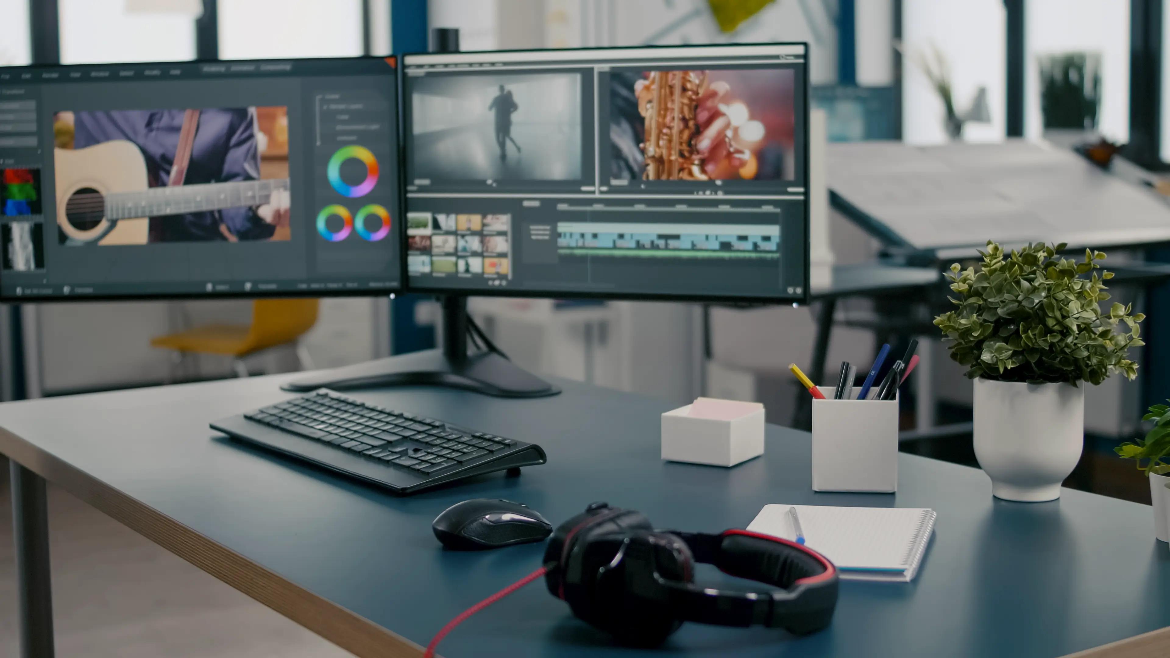 Professional video editing and animation workstation with a dual monitor setup displaying editing software, surrounded by essential equipment like headphones, keyboard, mouse, and potted plants for a creative workspace ambiance.