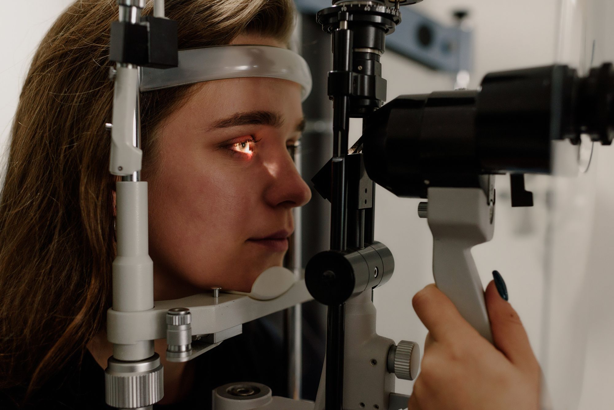 Woman undergoing an eye examination with a slit lamp
