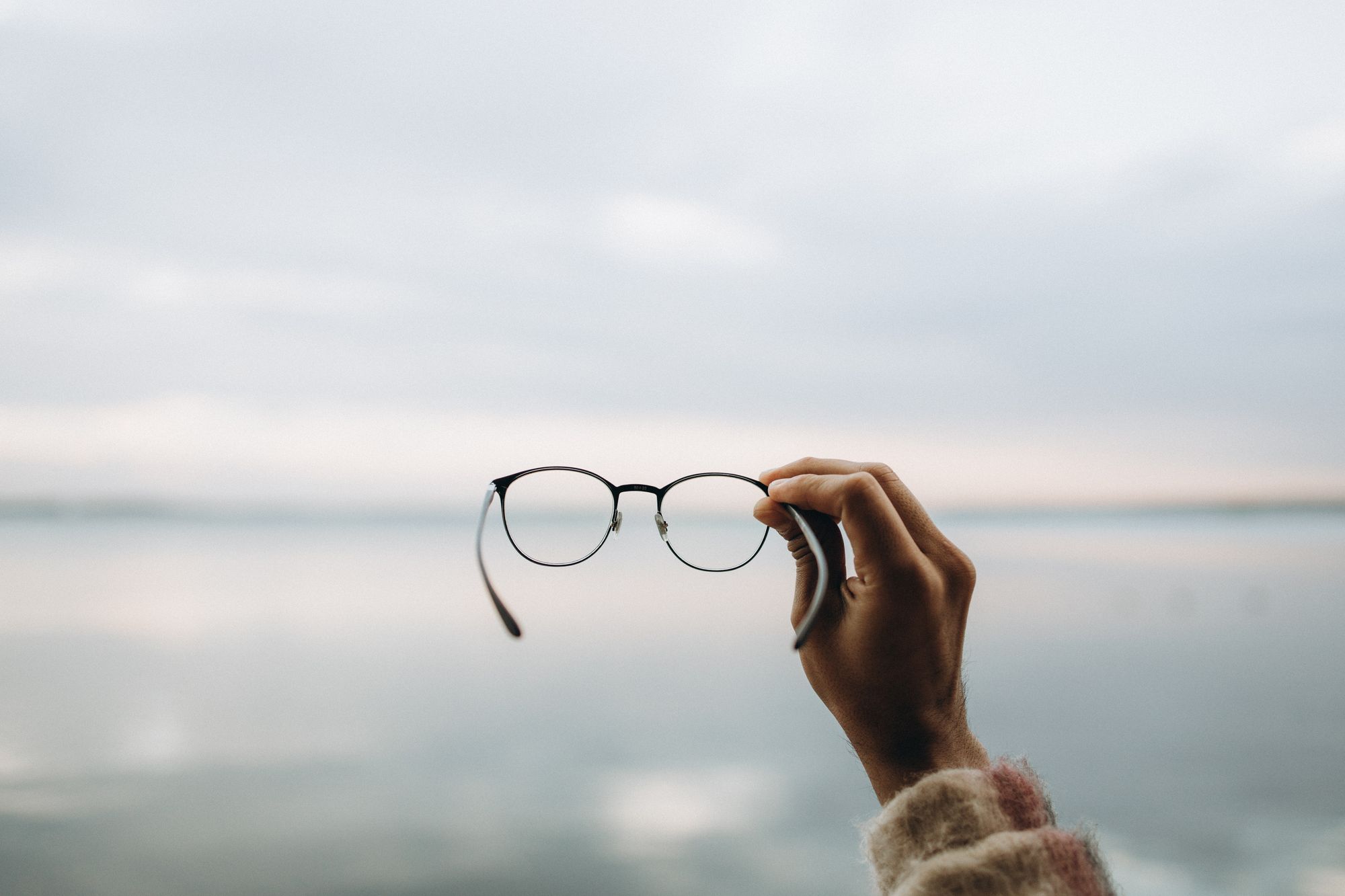 Person holding black-framed eyeglasses