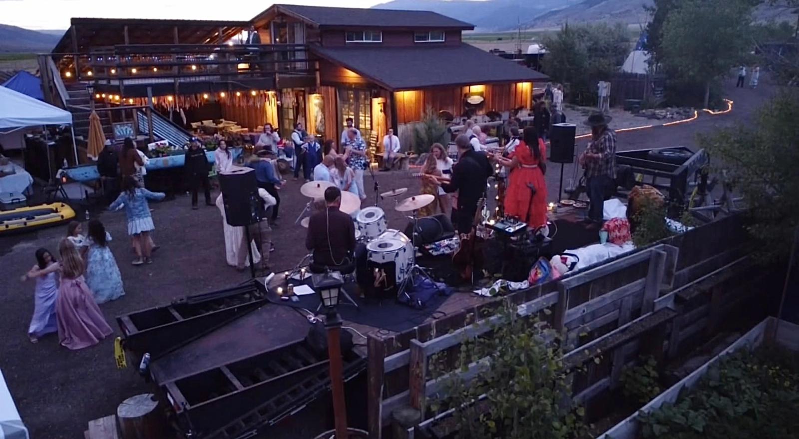A live band plays at dusk outside the Bourbon Barn while guests and kids dance under the lights