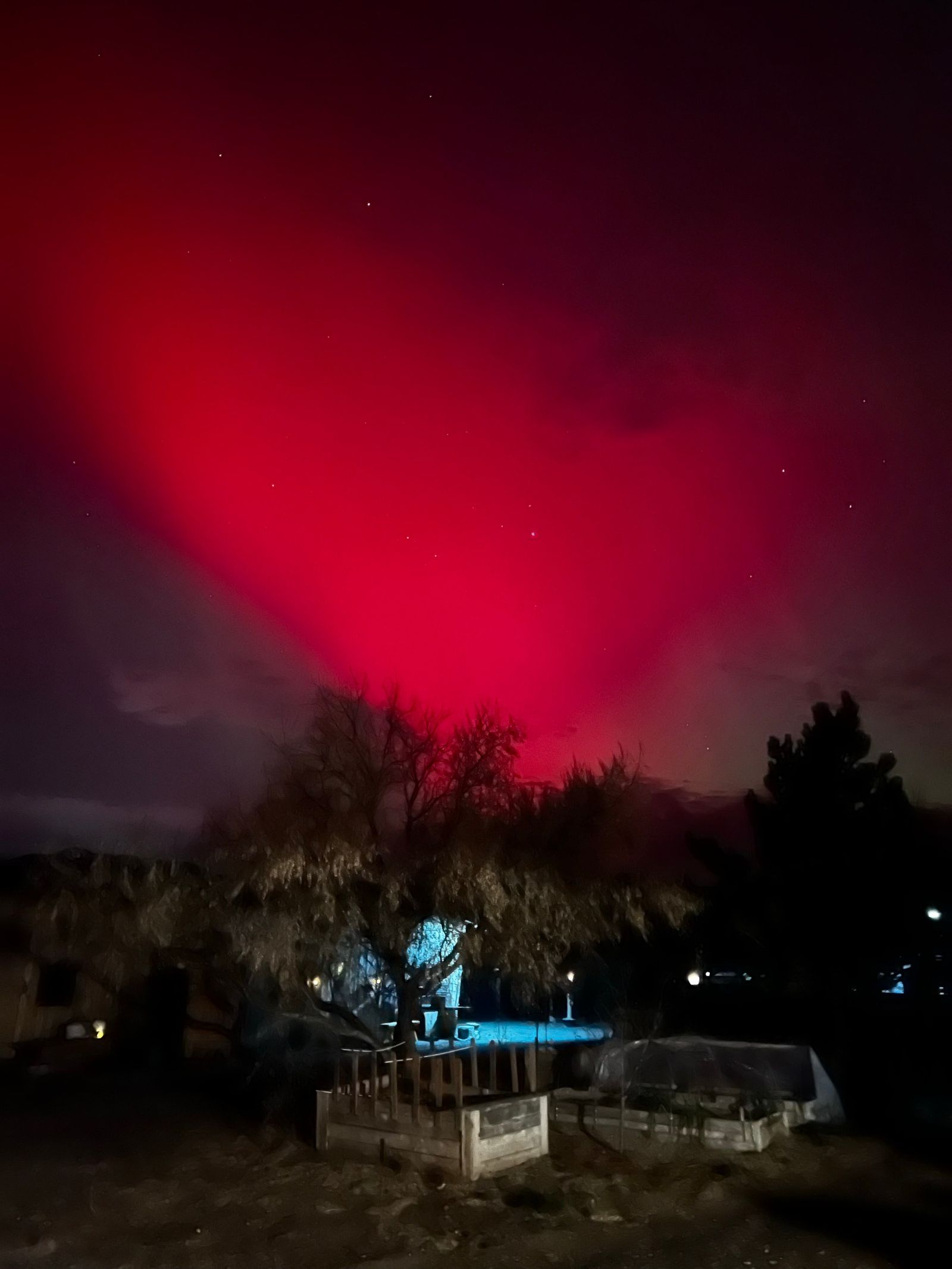 Northern lights glowing red over the farm at night