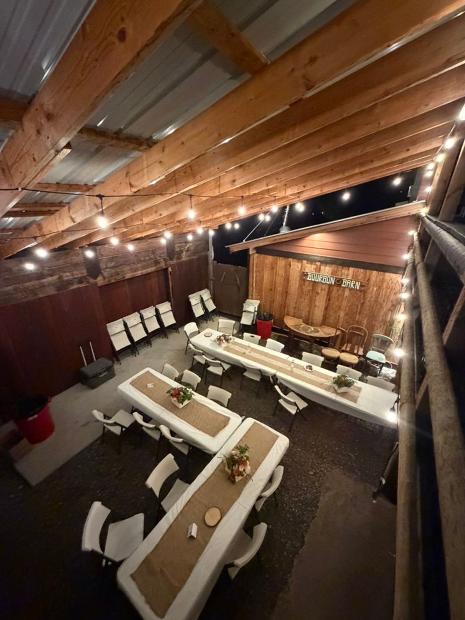 Long tables set for dinner inside the Bourbon Barn, seen from the loft