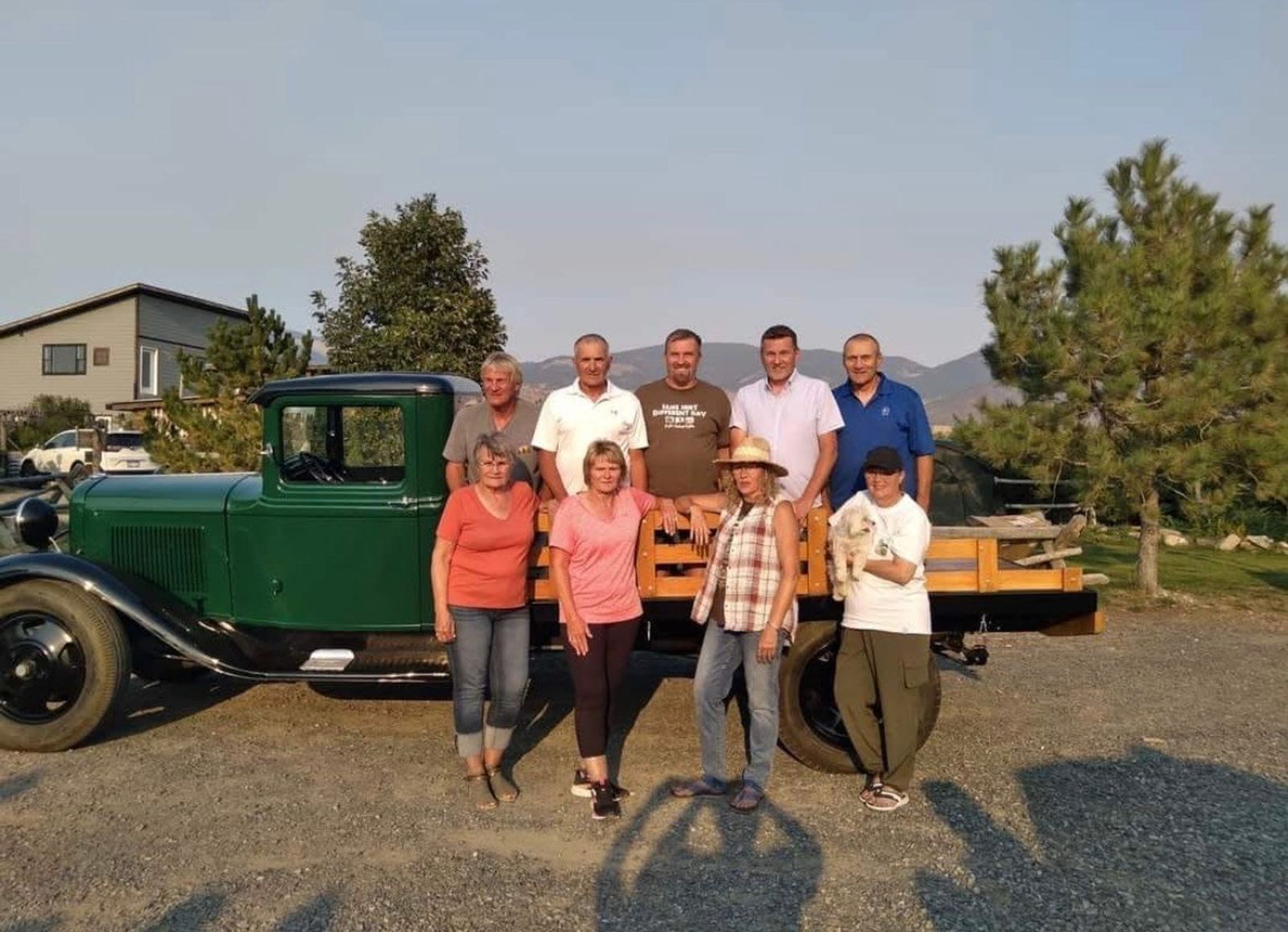 Friends gathered for a photo beside the 1932 Ford truck, the mountains behind
