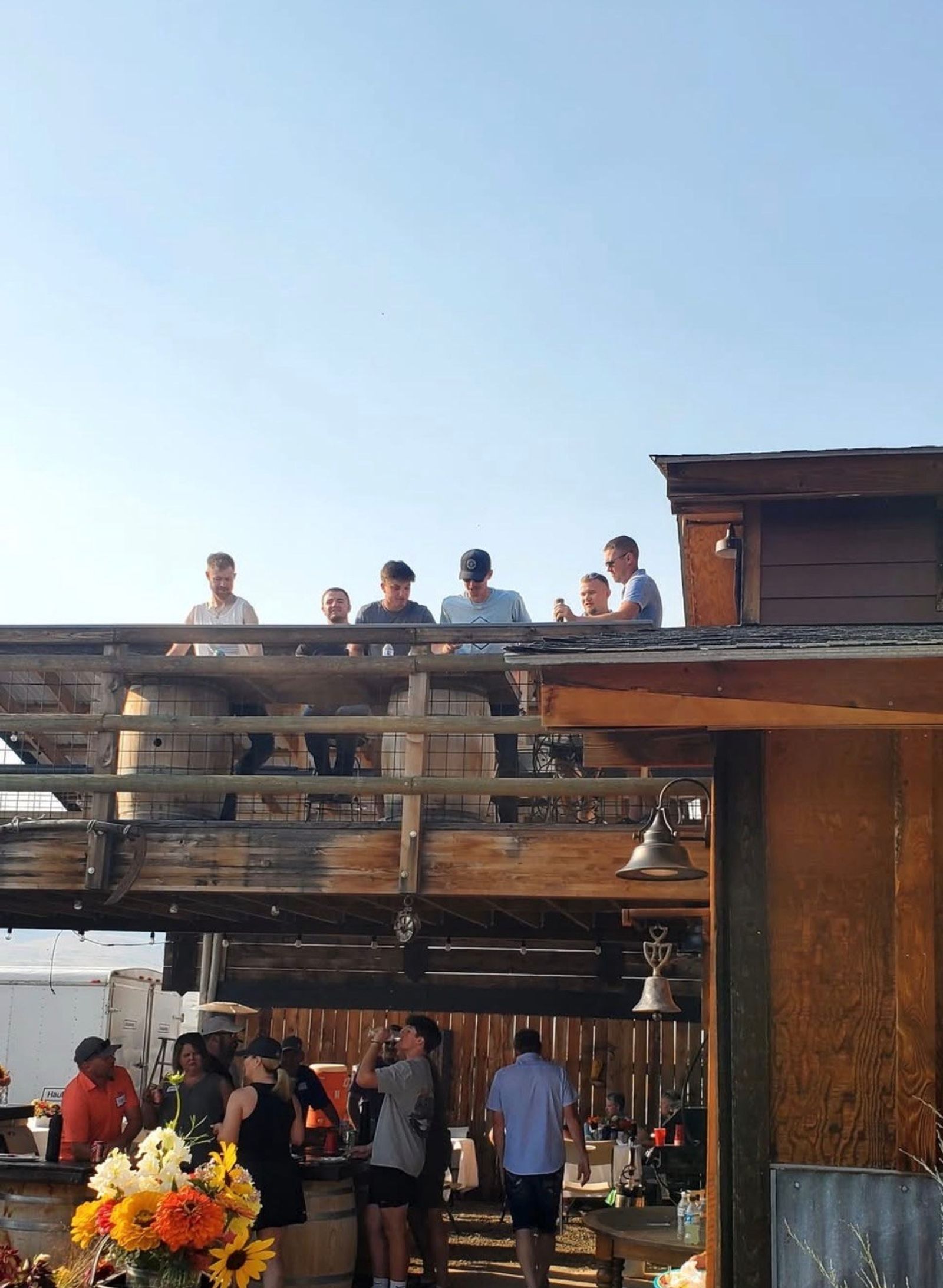 Guests up on the Bourbon Barn deck and gathered below, a farm dog wandering through