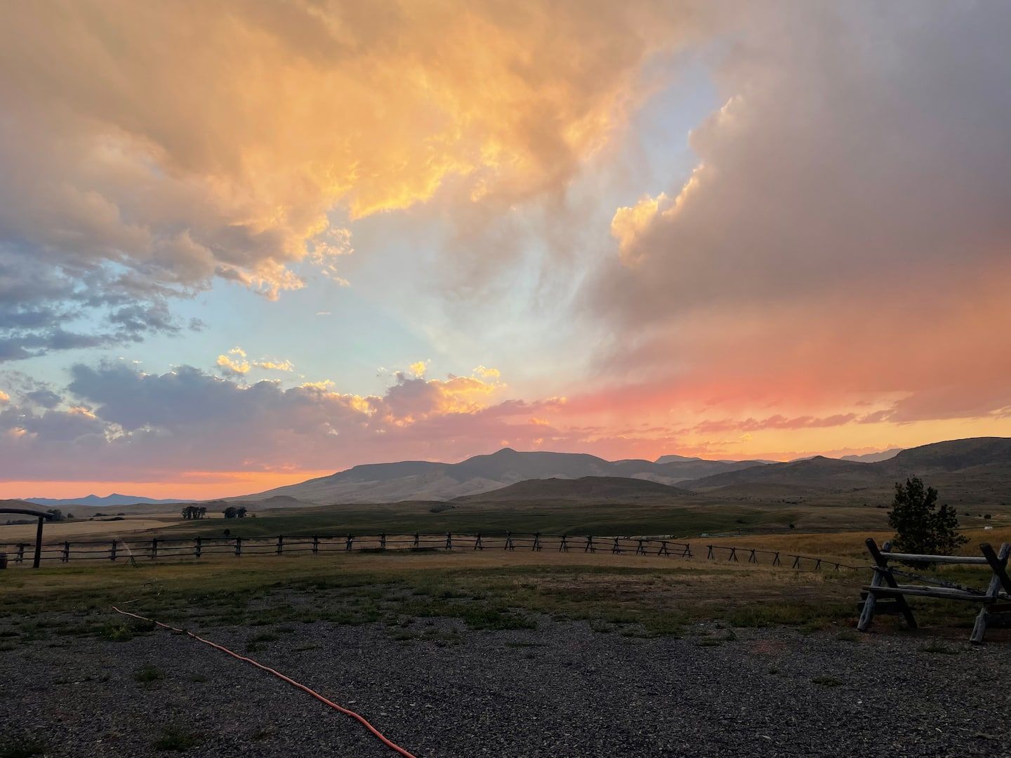 Sunset over irrigated ranchland and the buck-and-rail fence at the camper site