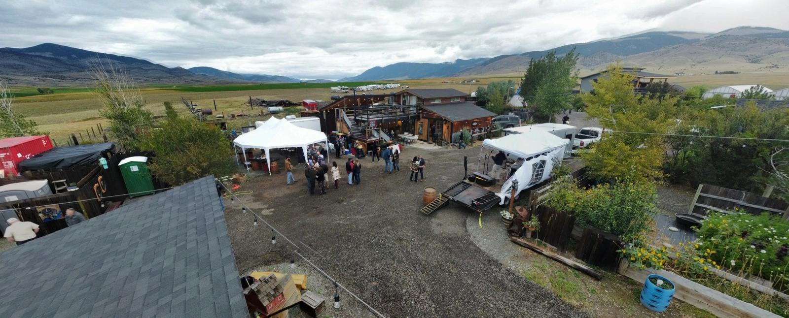 A celebration at the Bourbon Barn from above - tents, guests, and the Jefferson River Valley beyond