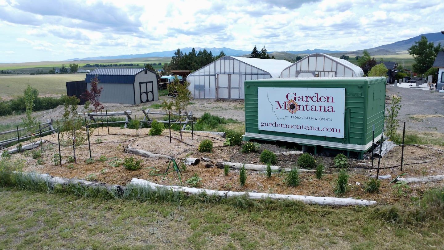 GardenMontana farm sign with greenhouses and mountains behind