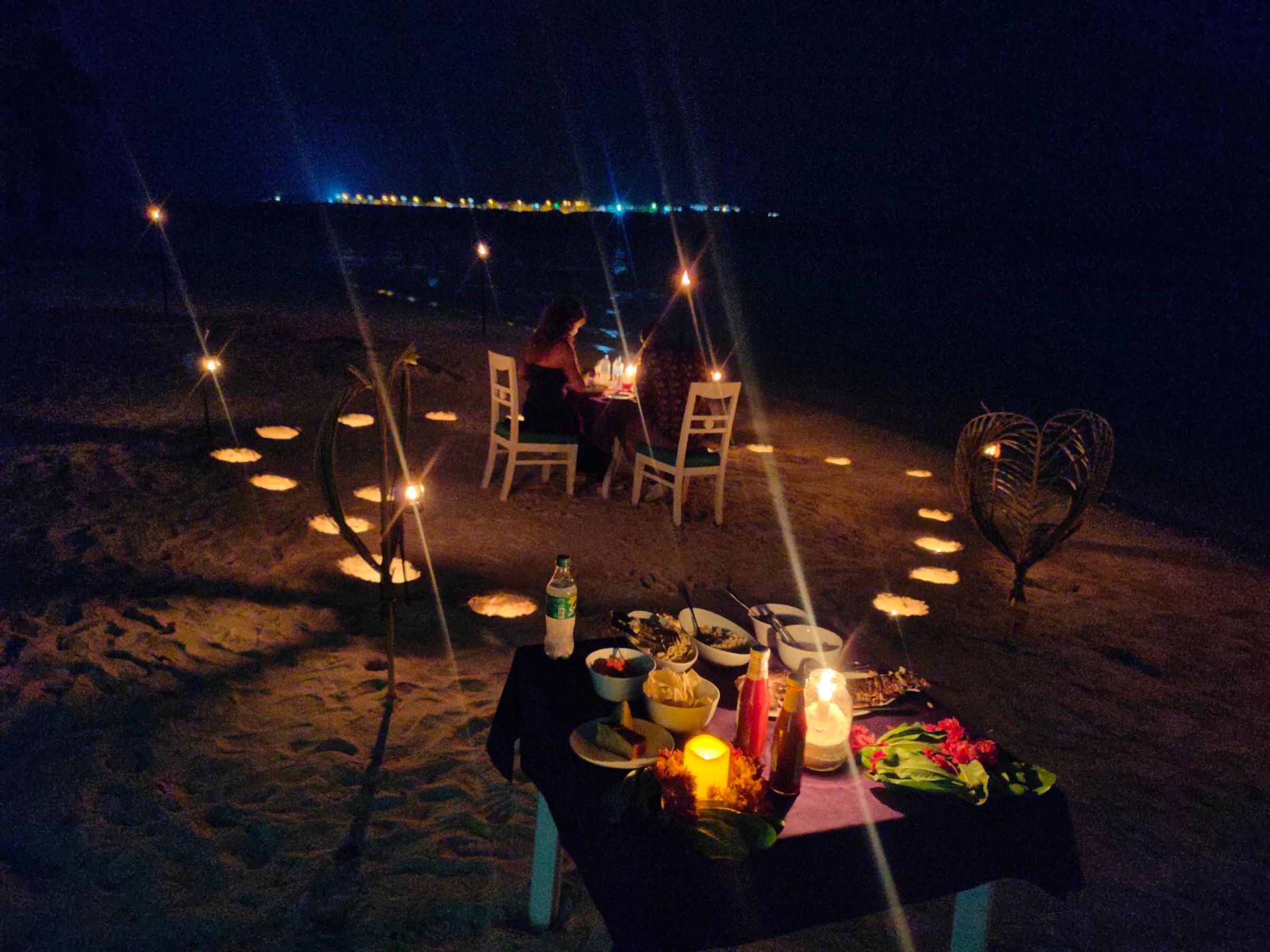 Cena en la playa iluminada con velas