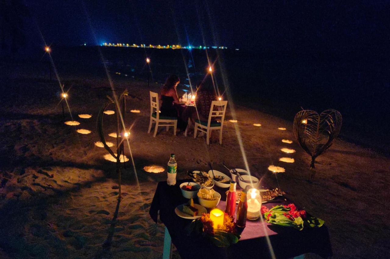 Cena en la playa iluminada con velas