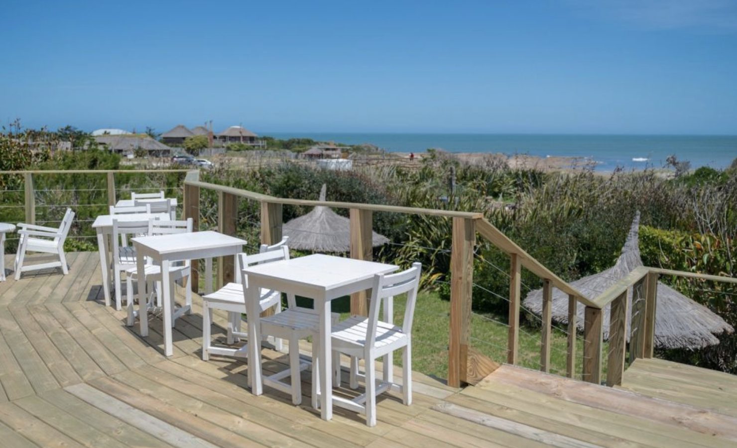 Deck con mesas y vista al mar en Portobello Suites