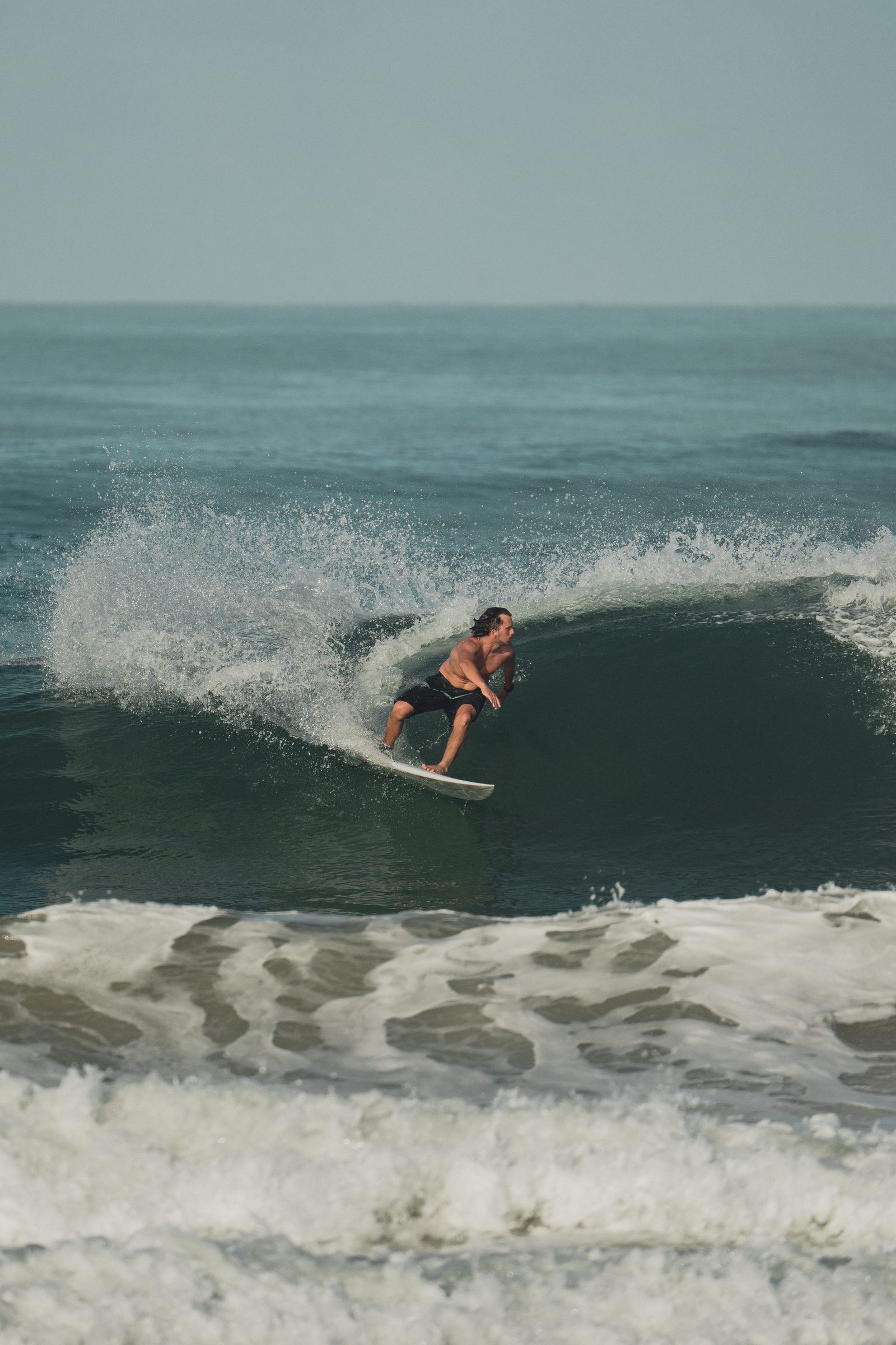 Surfista bajando una ola verde del Pacífico
