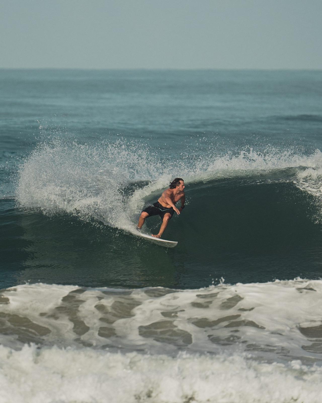 Surfista bajando una ola verde del Pacífico