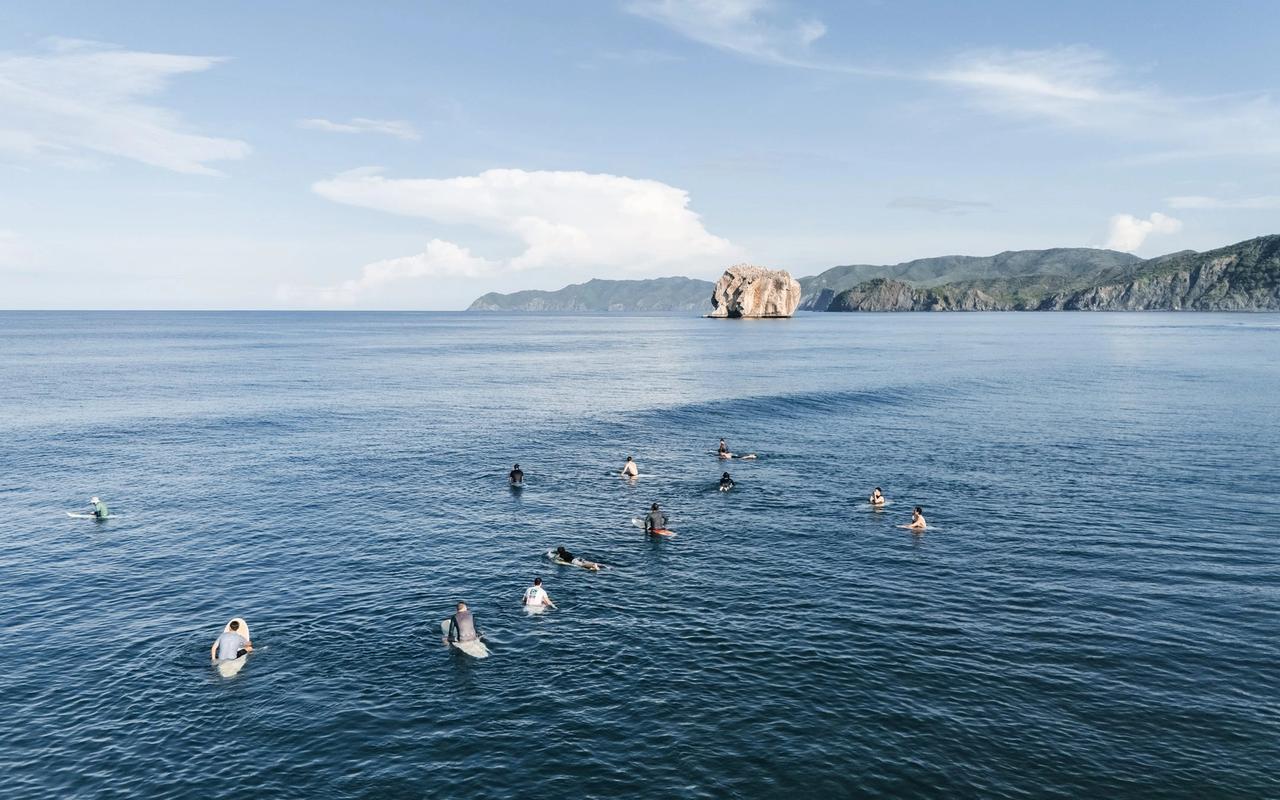 Surfistas esperando la ola en el pico, frente a Roca Bruja (Witch’s Rock)
