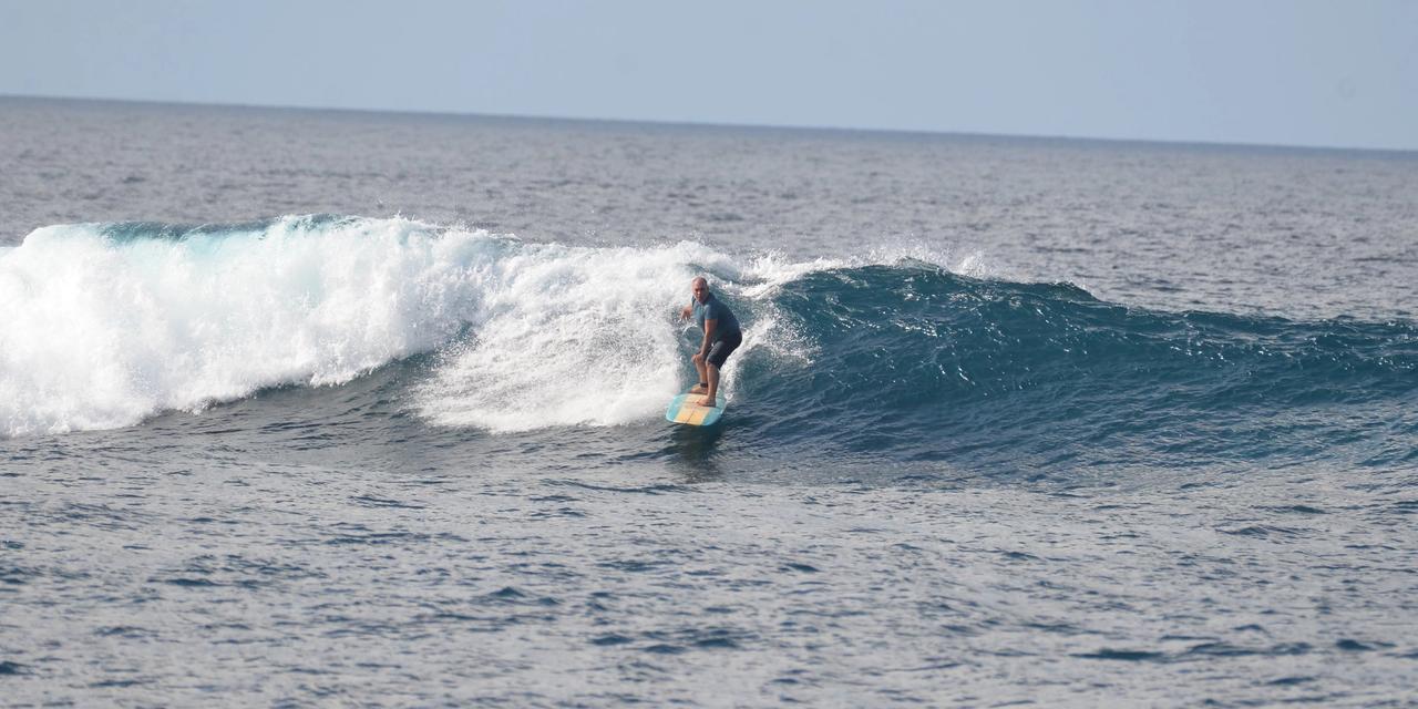 Surfista bajando una ola en Maldivas