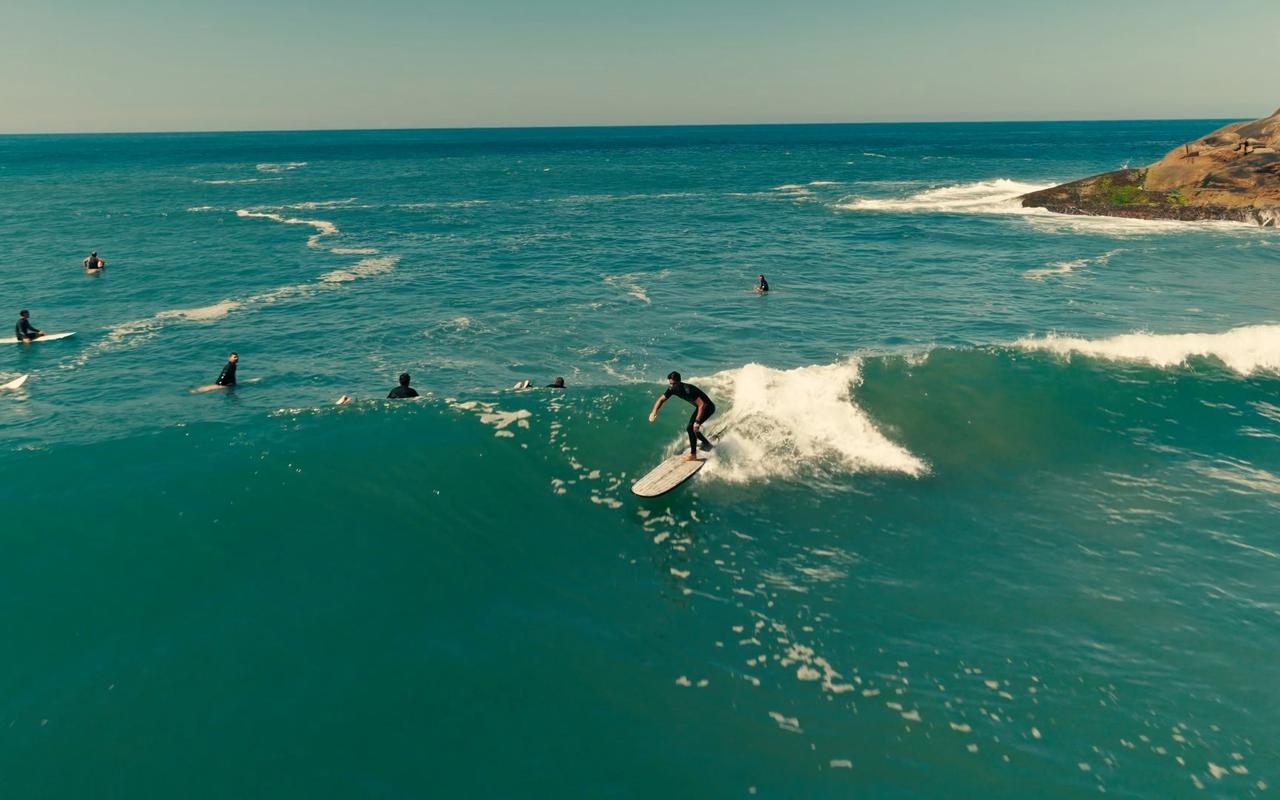 Surfista bajando una ola en Brasil, vista desde el aire