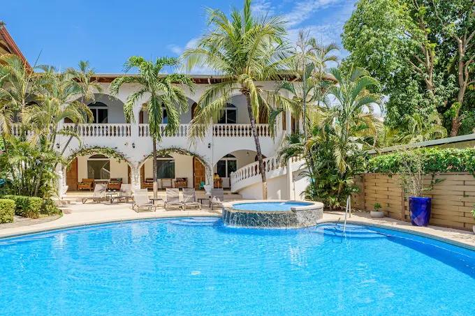 Piscina del alojamiento en Tamarindo rodeada de palmeras