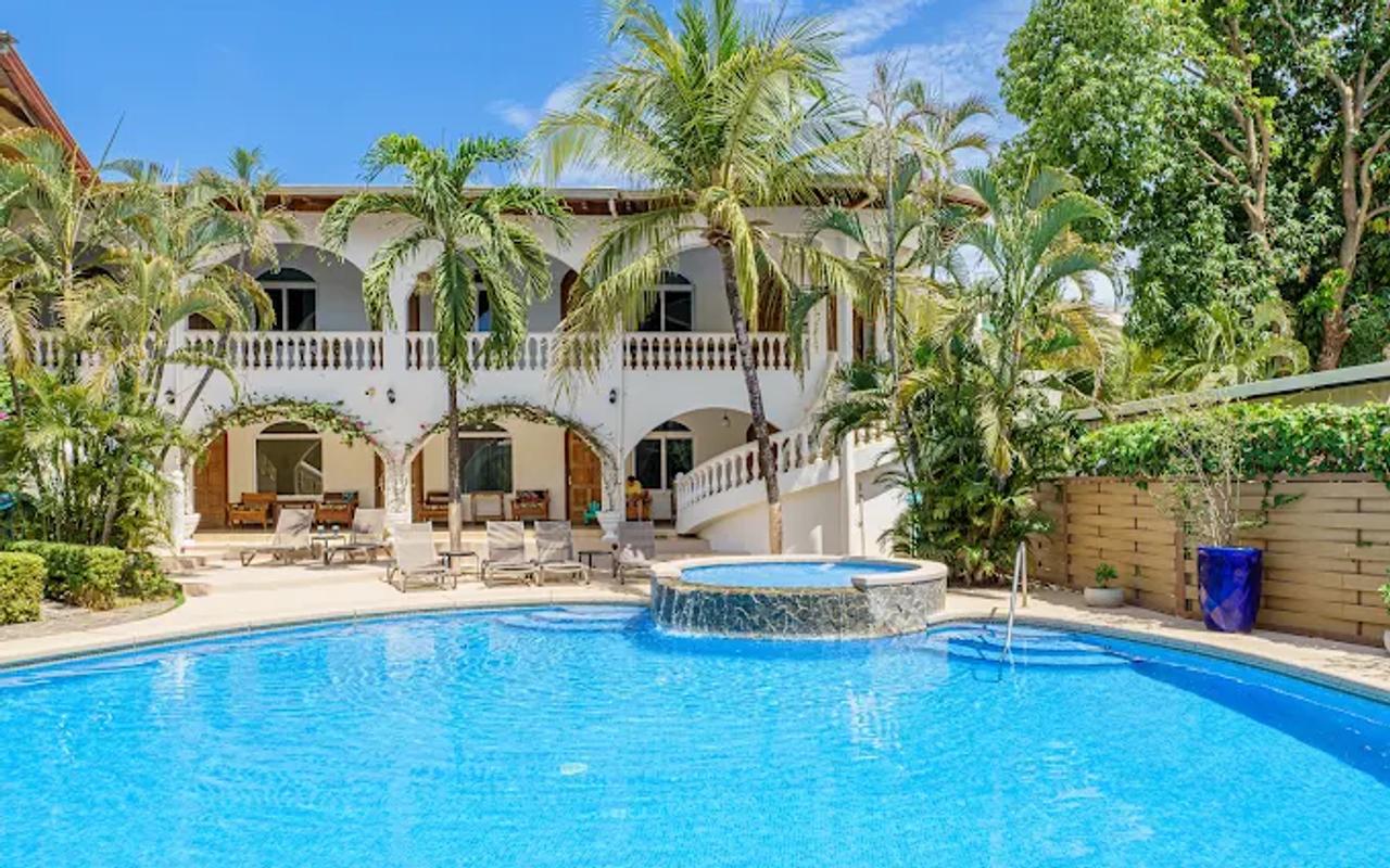 Piscina del alojamiento en Tamarindo rodeada de palmeras