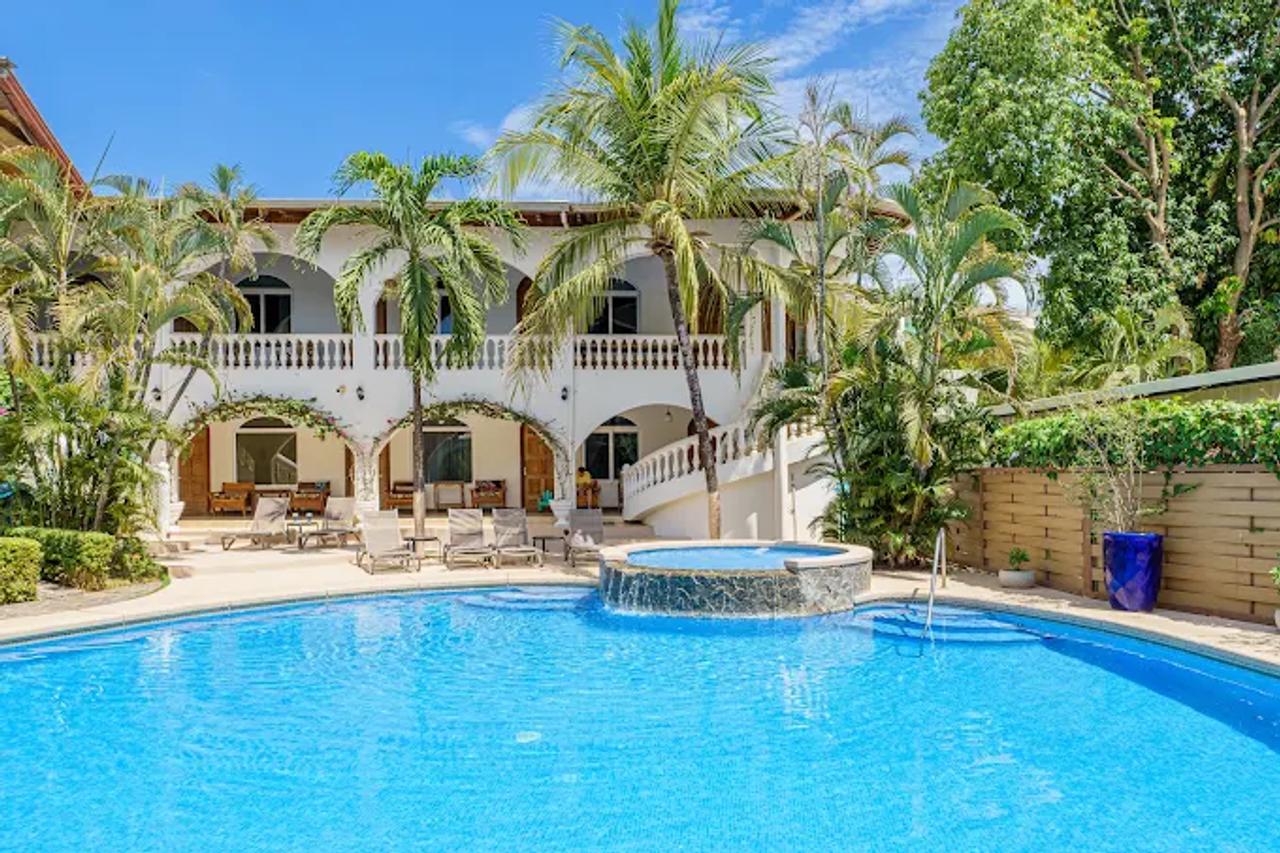 Piscina del alojamiento en Tamarindo rodeada de palmeras