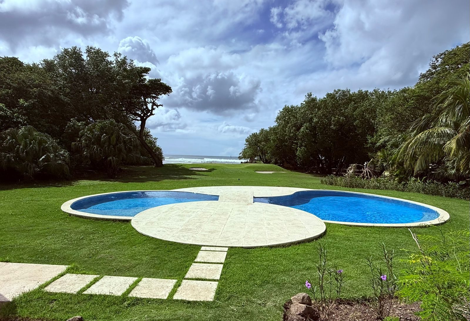 Piscina y jardín frente al mar en la casa de Hacienda Iguana