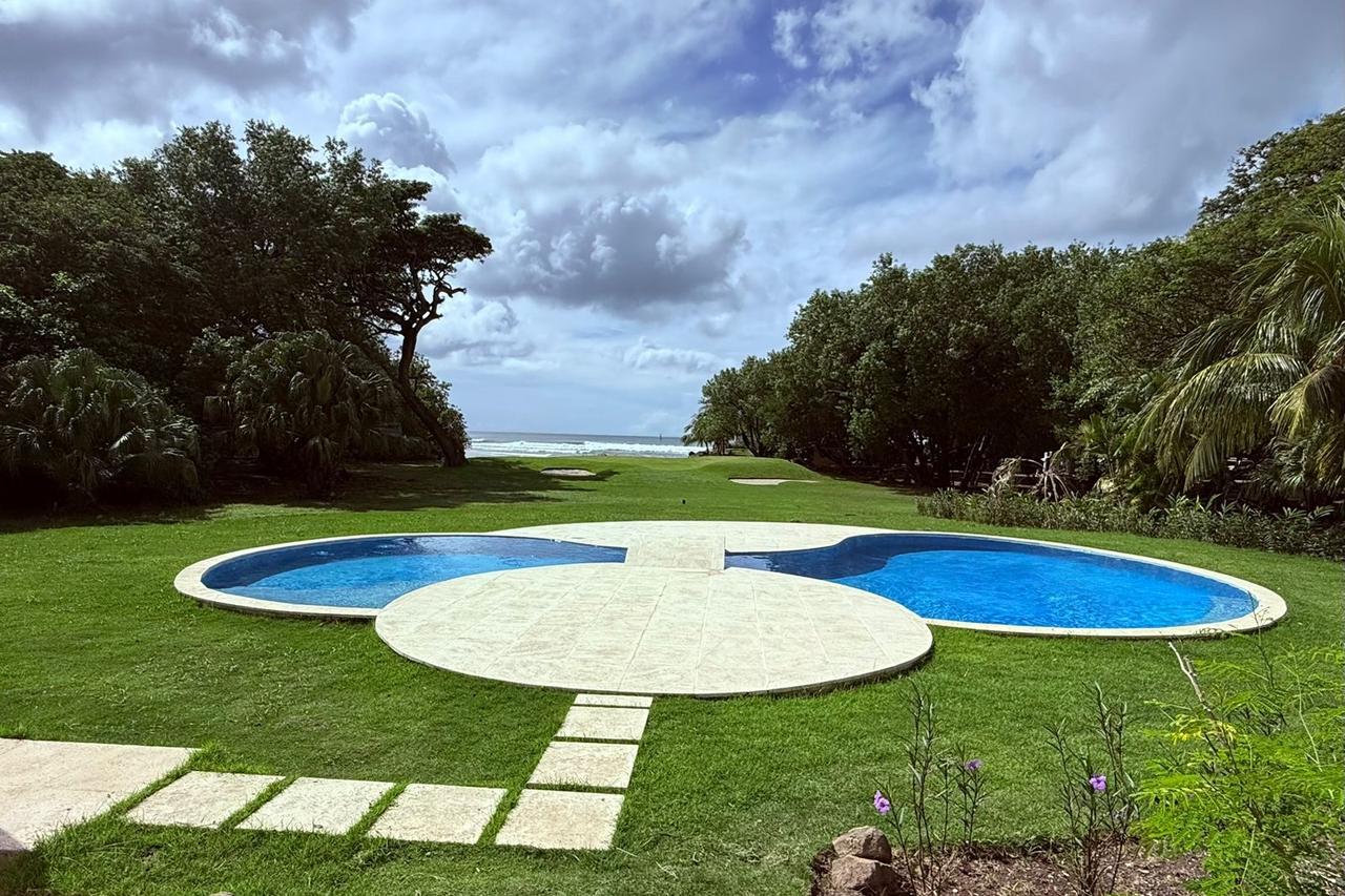 Piscina y jardín frente al mar en la casa de Hacienda Iguana